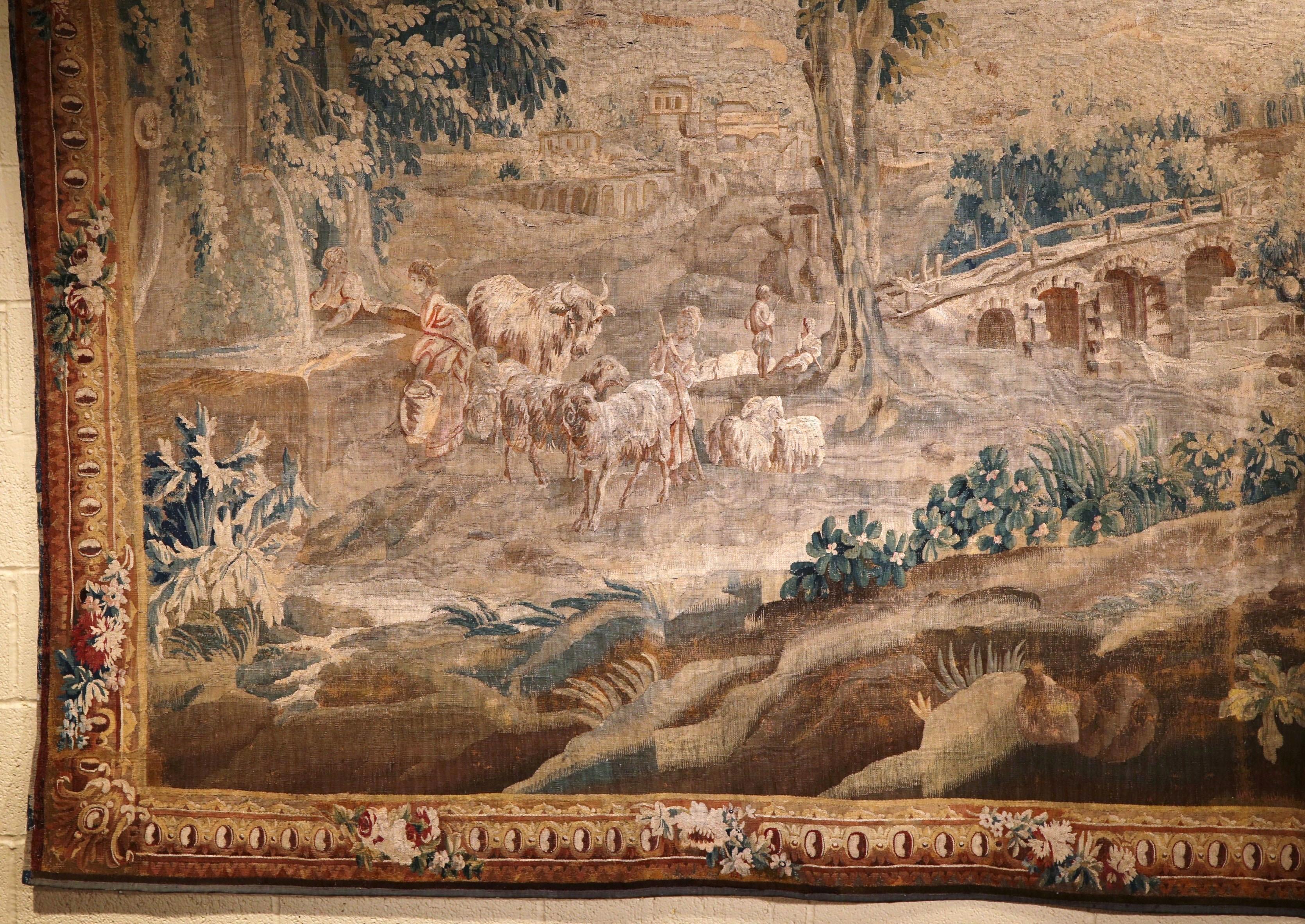 Make a statement in your home with this exquisite and important antique Aubusson tapestry. Created in France, circa 1740 in the style of Jean Baptiste Huet, the subject manner, set in the original border, depicts a pastoral scene with a shepherd,