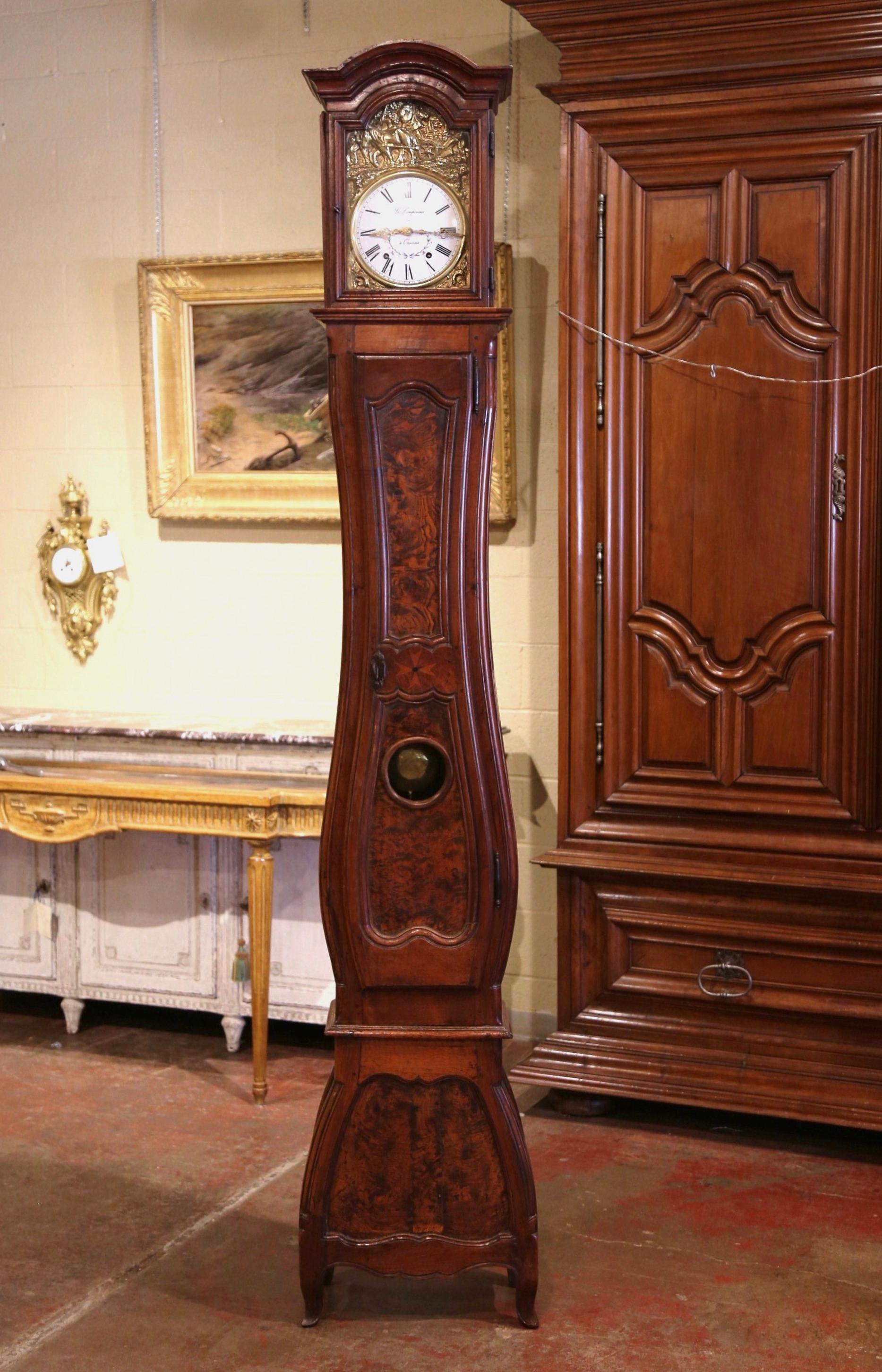 Crafted in Lyon, France, circa 1760 and built in one section, the antique fruitwood grandfather clock stands on curved feet over a scalloped apron, and features beautiful carved lines including a bonnet top over a violin shape body. The case with