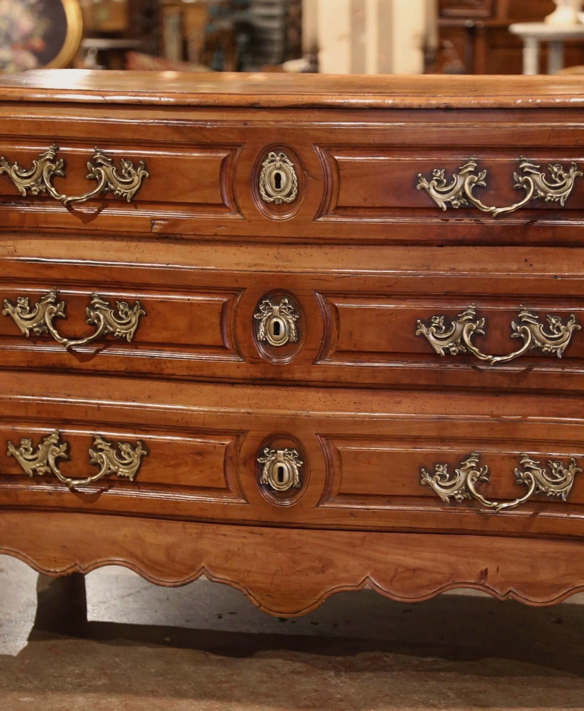 This large, antique chest of drawers was carved in Lyon, France, circa 1760. The elegant, fruitwood serpentine 