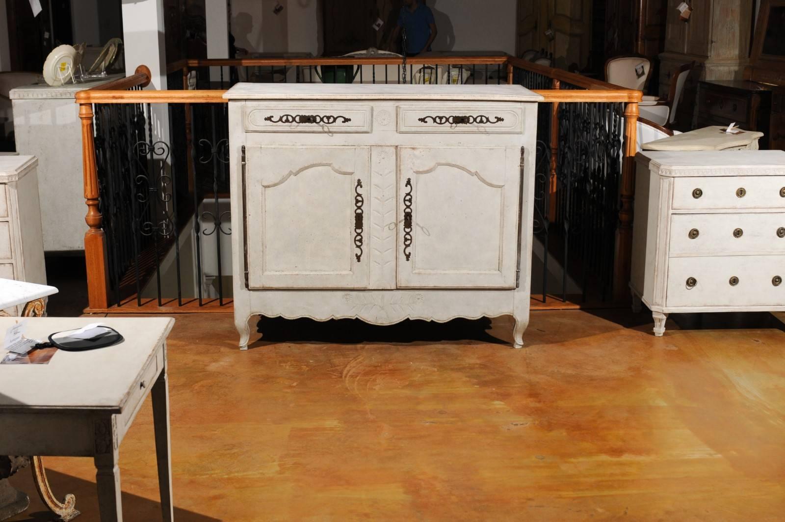 A French Louis XV period painted wood buffet from the mid-18th century, with two drawers over two doors and scalloped skirt. This French painted buffet features a rectangular, slightly raised top, sitting above two drawers. Each drawer is adorned