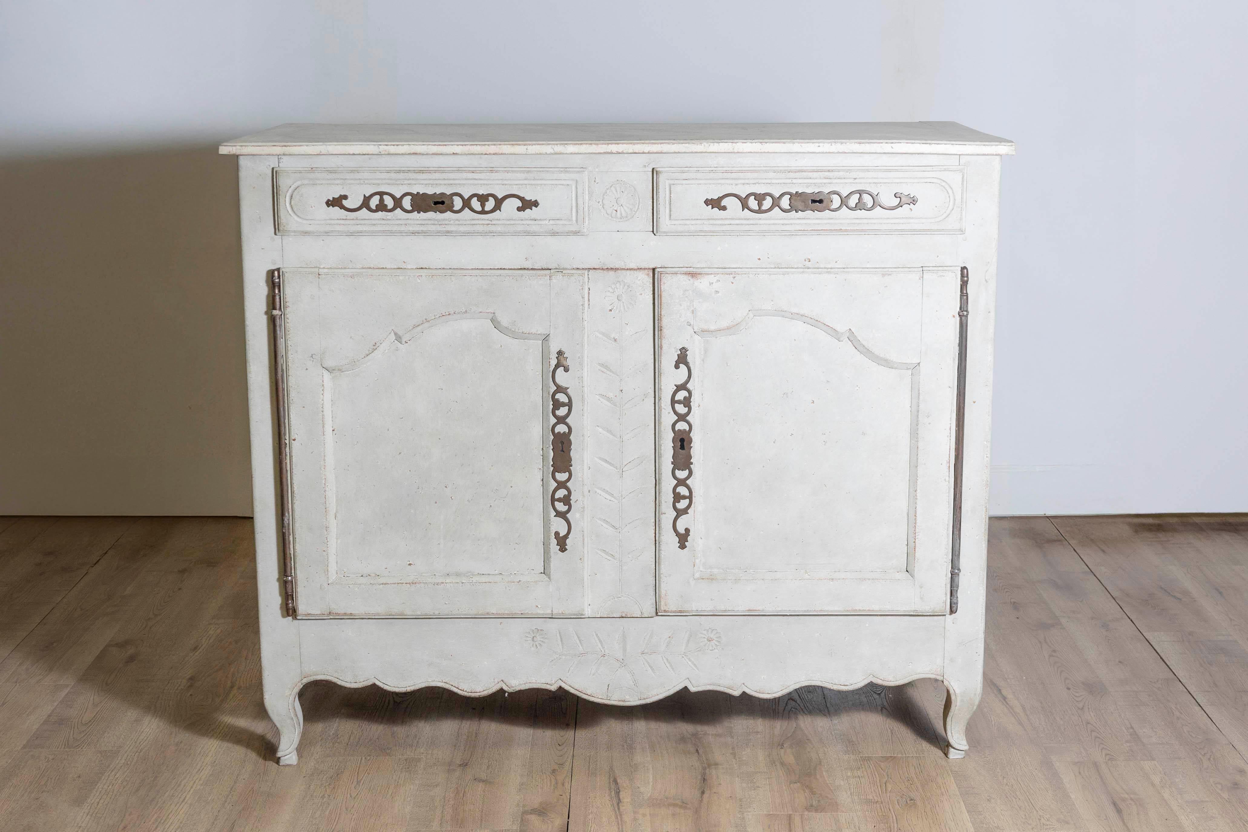 Un buffet francese in legno dipinto di epoca Luigi XV della metà del XVIII secolo, con due cassetti su due ante e gonna smerlata. Questo buffet francese dipinto presenta un piano rettangolare, leggermente rialzato, che si trova sopra due cassetti.