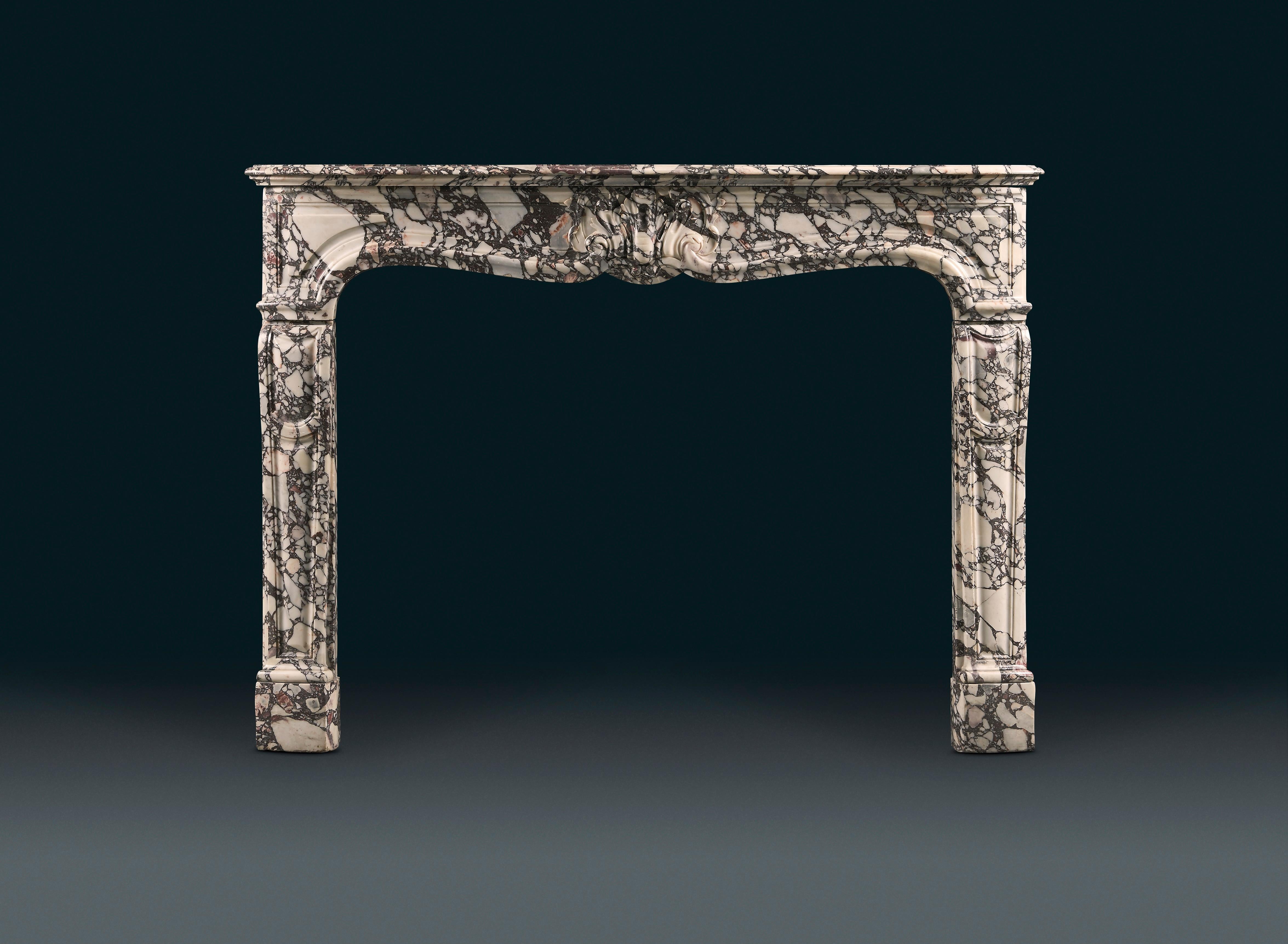 A pretty French, mid-18th century, Louis XV Rococo style fireplace in variegated Breche Violette marble from the Serravezza region of Carrara, of good color with bold lilacs and soft pinks on a white background. The serpentine moulded shelf with