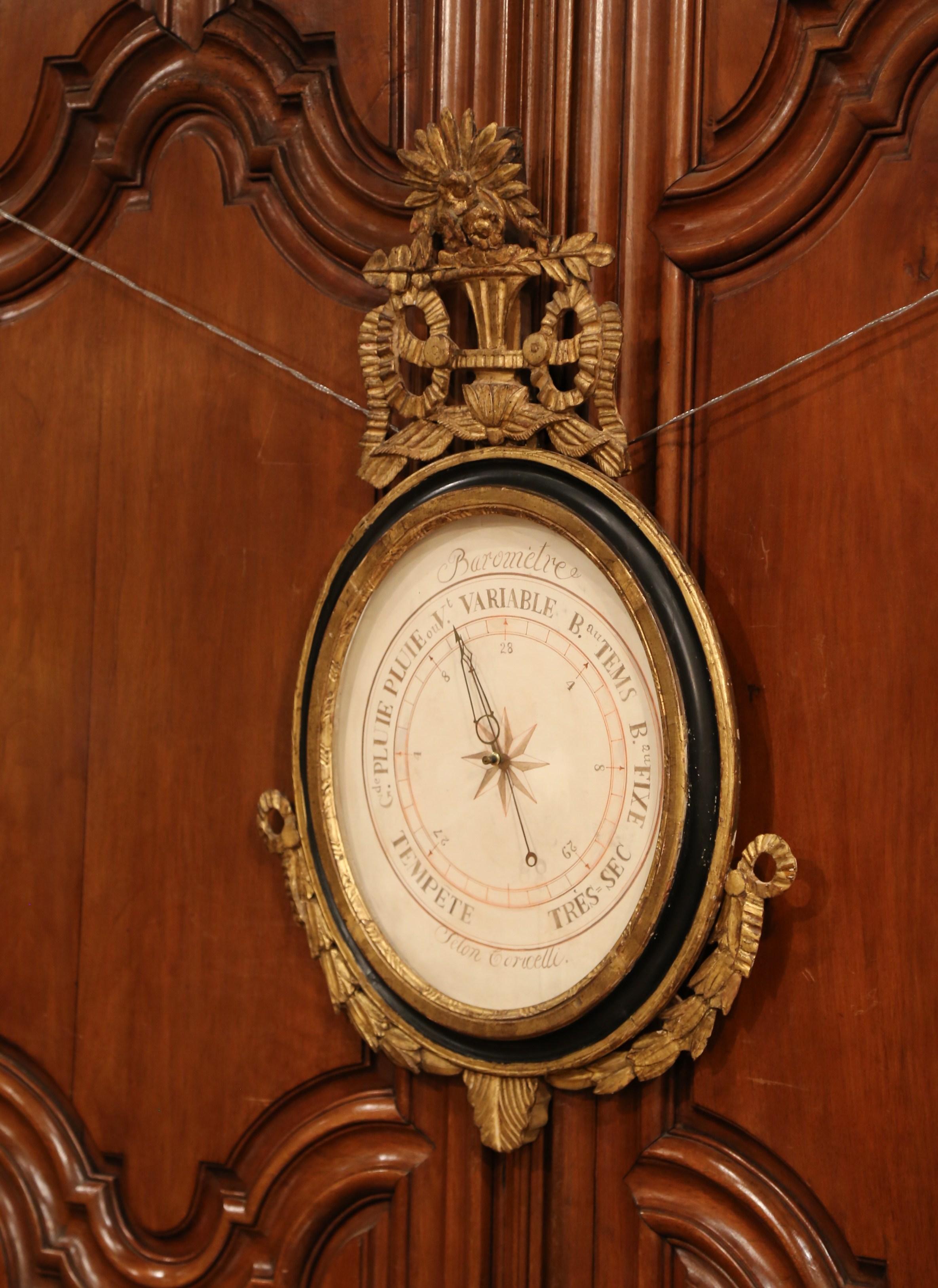 This elegant, antique Louis XVI barometer was crafted in Paris, France, circa 1760. The large oval shaped wall piece features its original hand painted parchment paper barometer with French inscriptions written in Indian ink. The frame is adorned