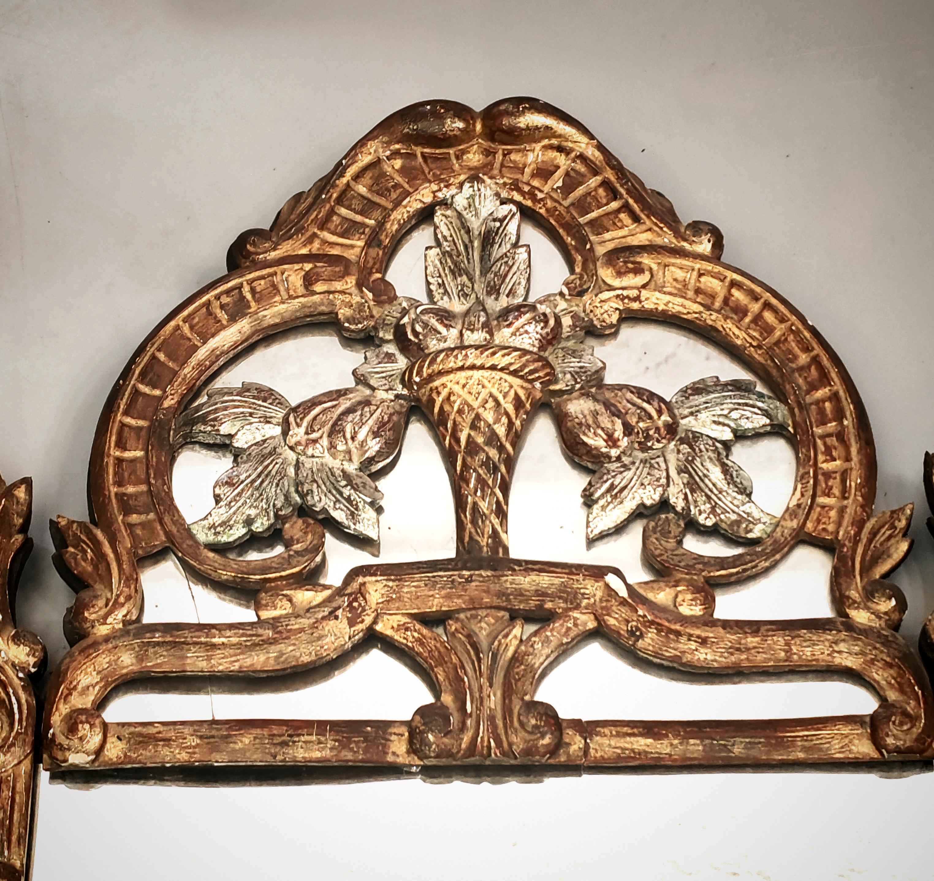 La cornice di questo lussuoso specchio è realizzata in legno intagliato e dorato, con dettagli argentati e dipinti di verde. La doratura è realizzata con la tecnica tradizionale di doratura degli oggetti con foglia d'oro. Alcuni elementi della