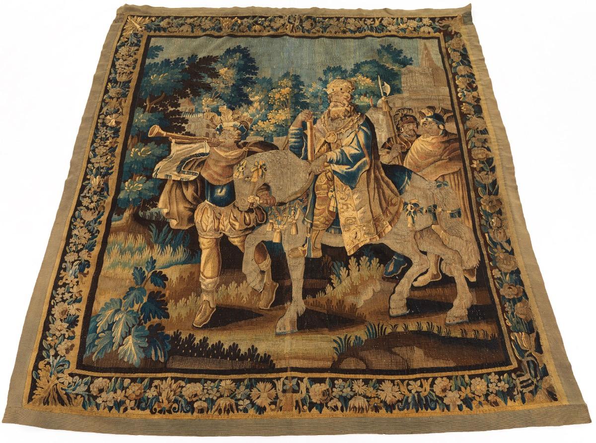 Beauvais, France. Depicts arrival at a castle, royal horse being heralded by trumpeter and escorted by two guards, continuous floral border and two minor borders. Linen and wool slit weave Beauvais technique with natural indigo, weld, walnut husk,