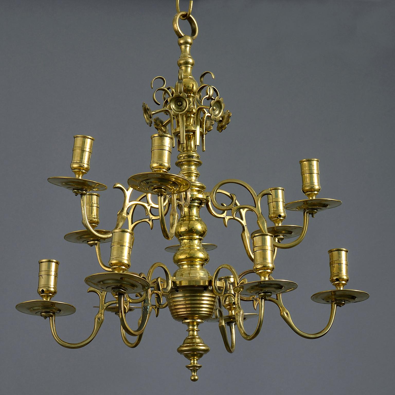 A mid 18th century George II brass chandelier the knopped centre issuing 12 scrolling branches over two tiers.