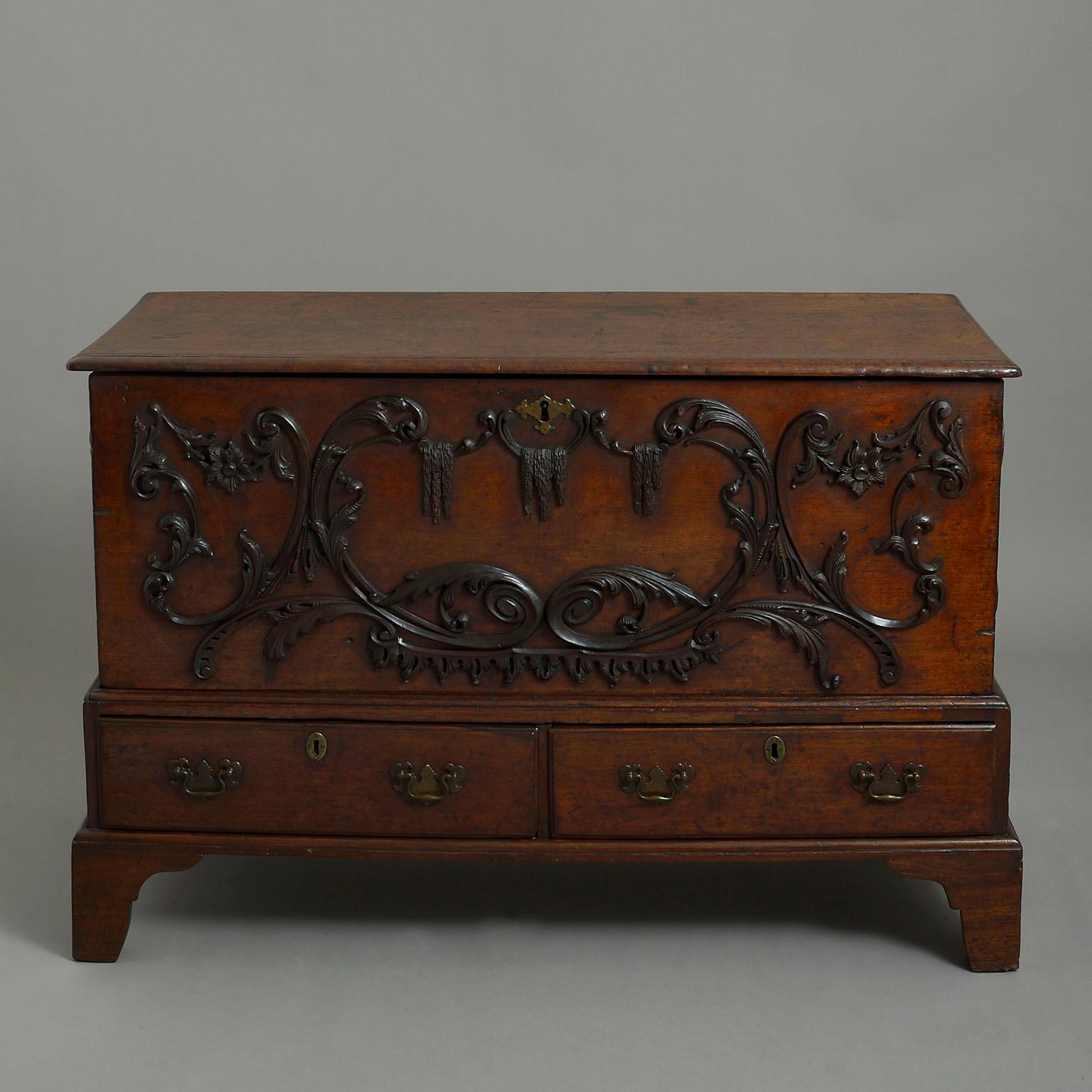 Mid-18th century mahogany mule chest in the manner of Wright & Elwick, the coffer with hinged lid standing on a separate base with two drawers over bracket feet, the front and sides applied with elaborate Rococo carving.