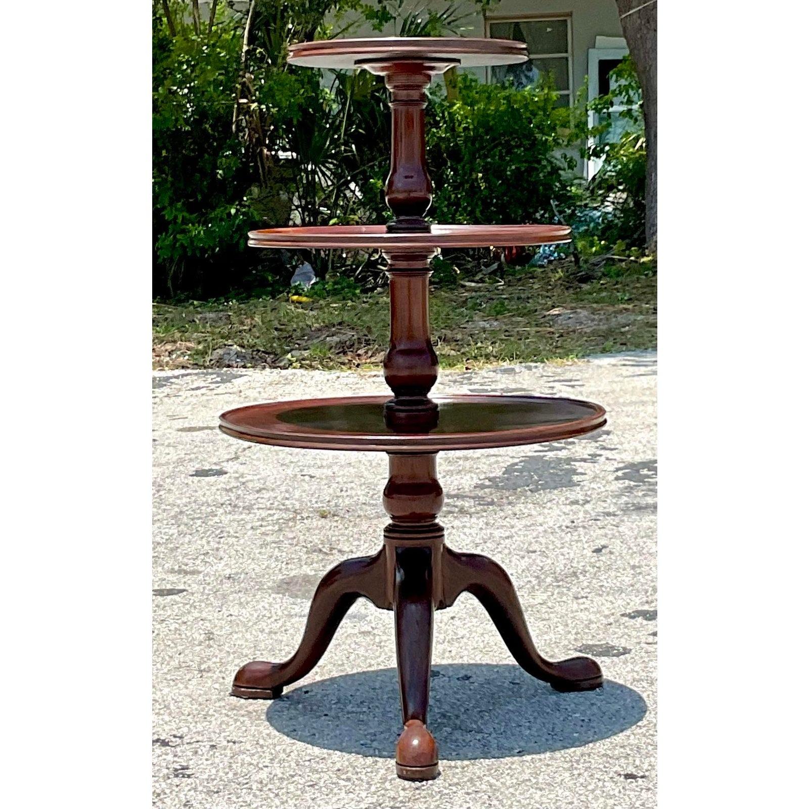 A gorgeous vintage George III style mahogany dumbwaiter with central baluster and three shelves, each with fluted piecrust edges, resting on a tripod of Queen Anne pad feet. Acquired at a Palm Beach estate.