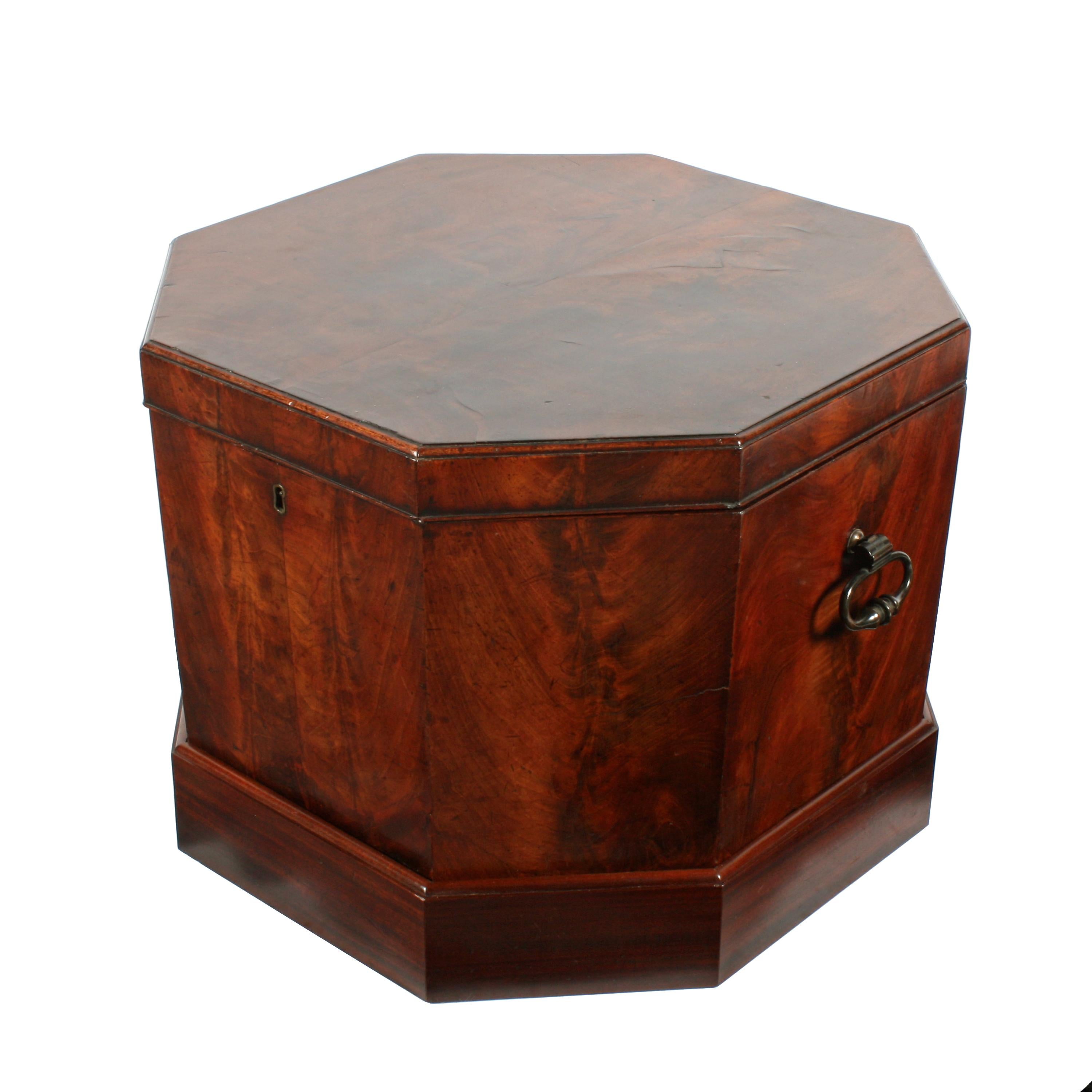 A mid-18th century early George III octagonal mahogany cellaret.

The cellaret is veneered in flamed mahogany, has a pair of original bronze carrying handles and stands on a later plinth base.

The interior has the original mahogany bottle