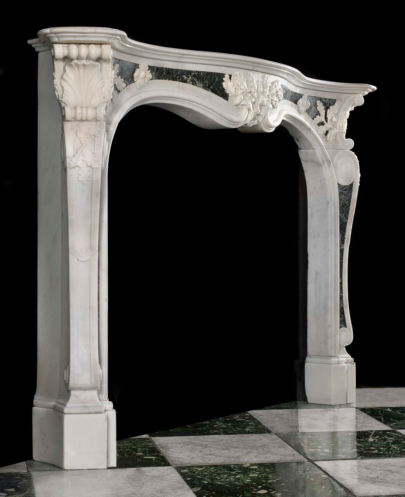 An important, rare mid-18th century Georgian English Rococo antique fireplace surround in Statuary and Maurin green marble influenced by the designs of Sir Henry Cheere (1703-1781) and Isaac Ware (1704-1766). The serpentine shelf rests above a