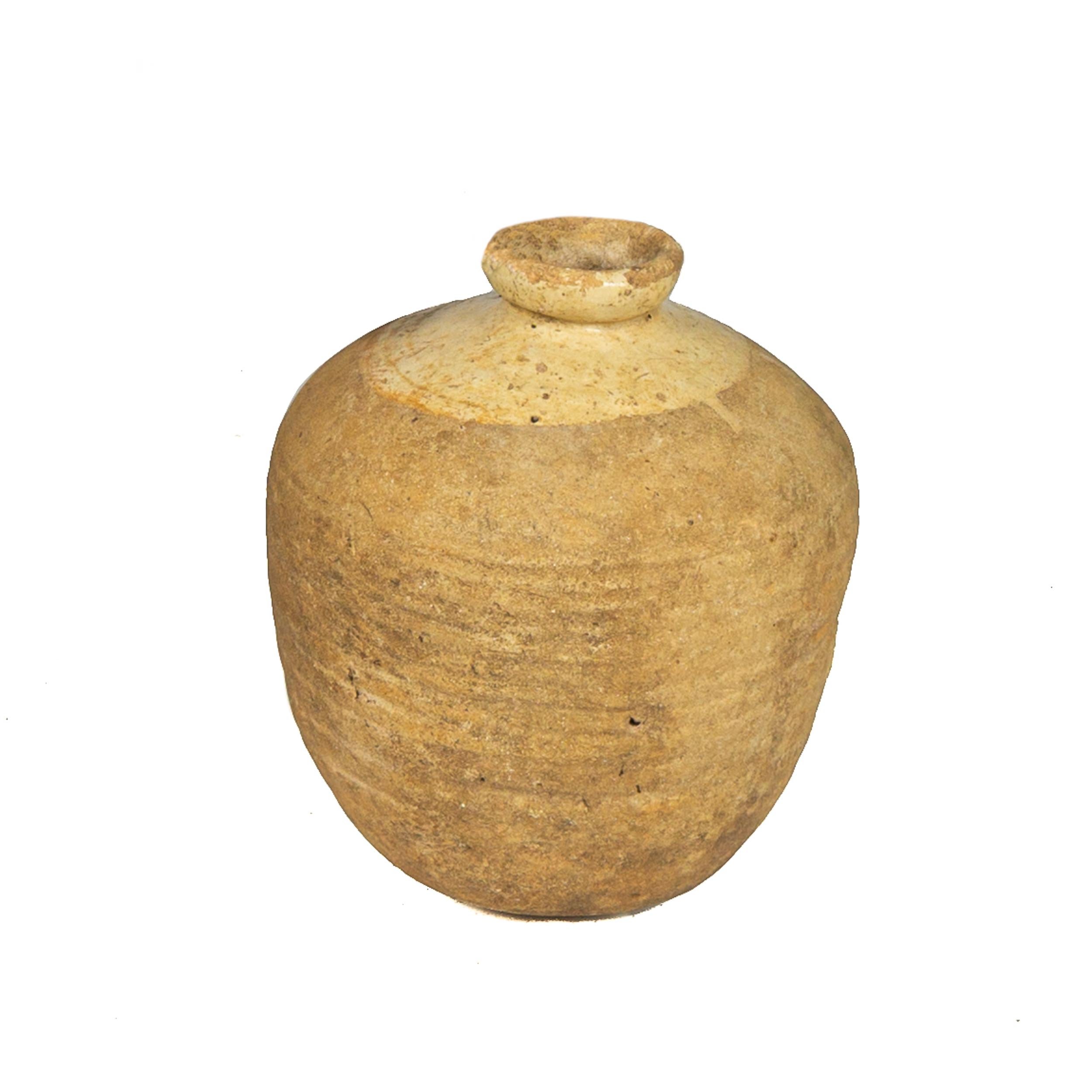 Esta elegante tinaja antigua fue fabricada a mano en España hacia 1760; de forma redonda con base y cuello estrechos, la vasija presenta un borde enrollado en la parte superior acentuado con un acabado vidriado de color mostaza. La pieza española