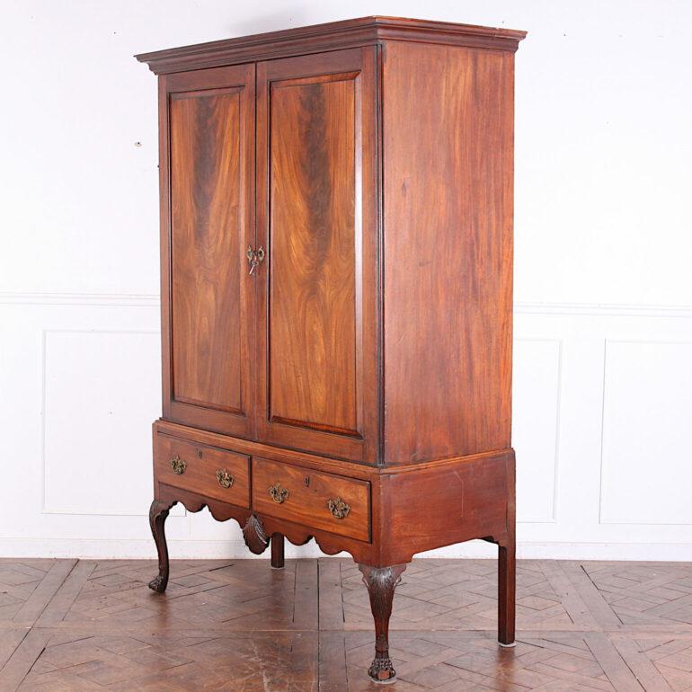 Irish solid mahogany George II cabinet on stand or linen press, the upper doors with flame mahogany fielded panels opening to several pull-out shelves and with a pair of oak-lined drawers below.
Upper cabinet with pull-out surfaces; inner door