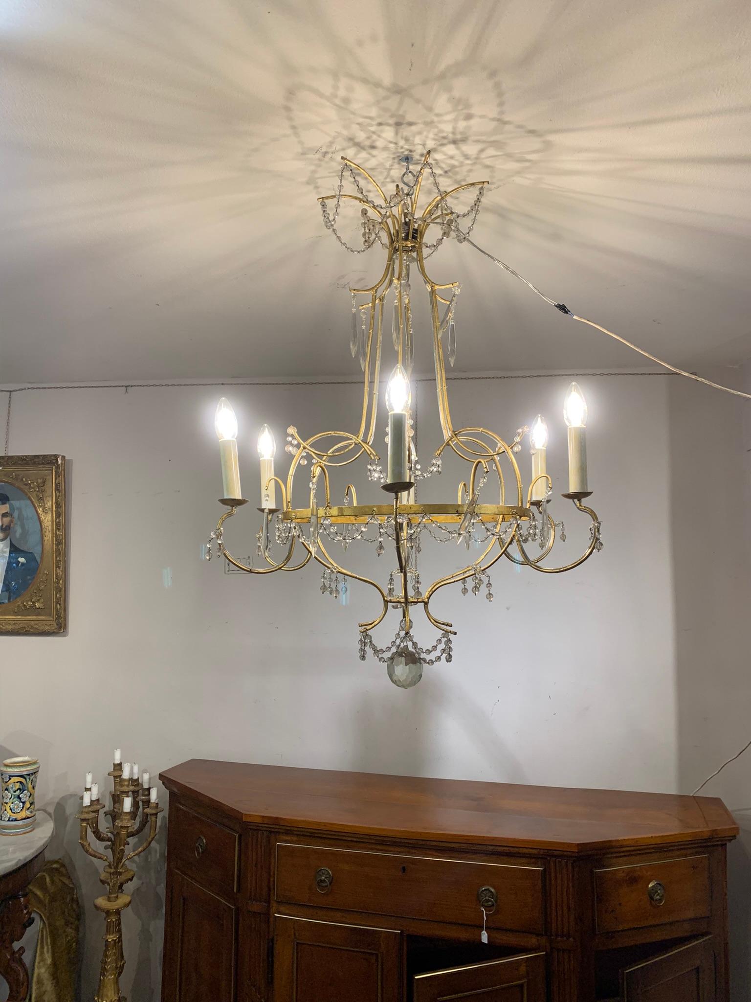 Beautiful chandelier with gilded iron structure and crystal pendants, six candle holder arms.
Very light and small in Size, suitable for rooms that are not too large.
MEASUREMENTS: H cm 90, Diameter cm 70.