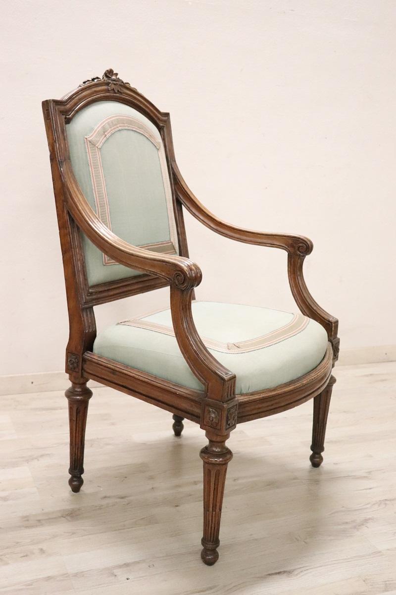 Beautiful 18th century of the period Louis XVI Italian antique armchair in solid walnut wood. An imposing large armchair with a wide and comfortable seat. Very linear characterized by small and refined decorations carved into the wood. In perfect