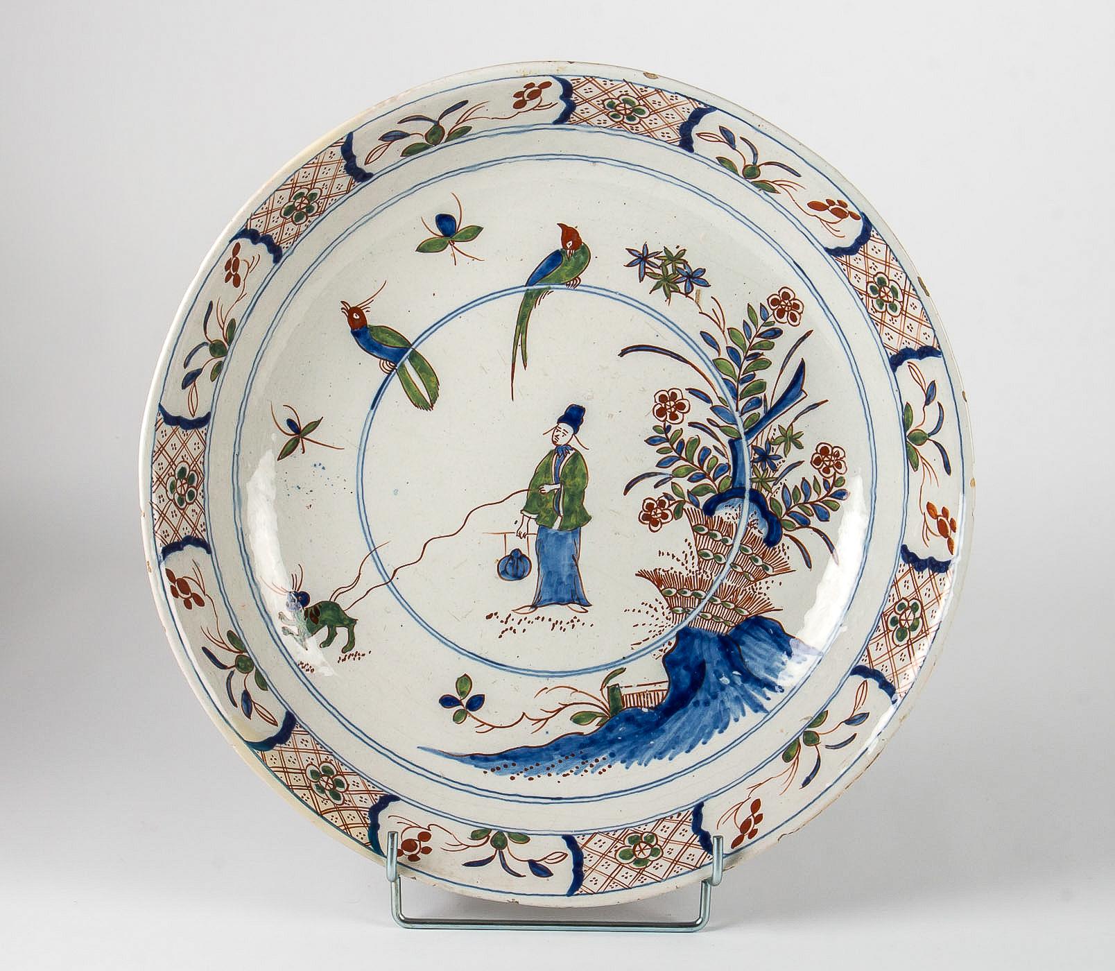 Mid-18th century, large Faience Delft round dish, circa 1720-1750

Magnificent and decorative large Delft polychrome hand painted earthenware round dish, depicting a Chinese man holding a tiger on a leash surrounded by birds and flowers. On the