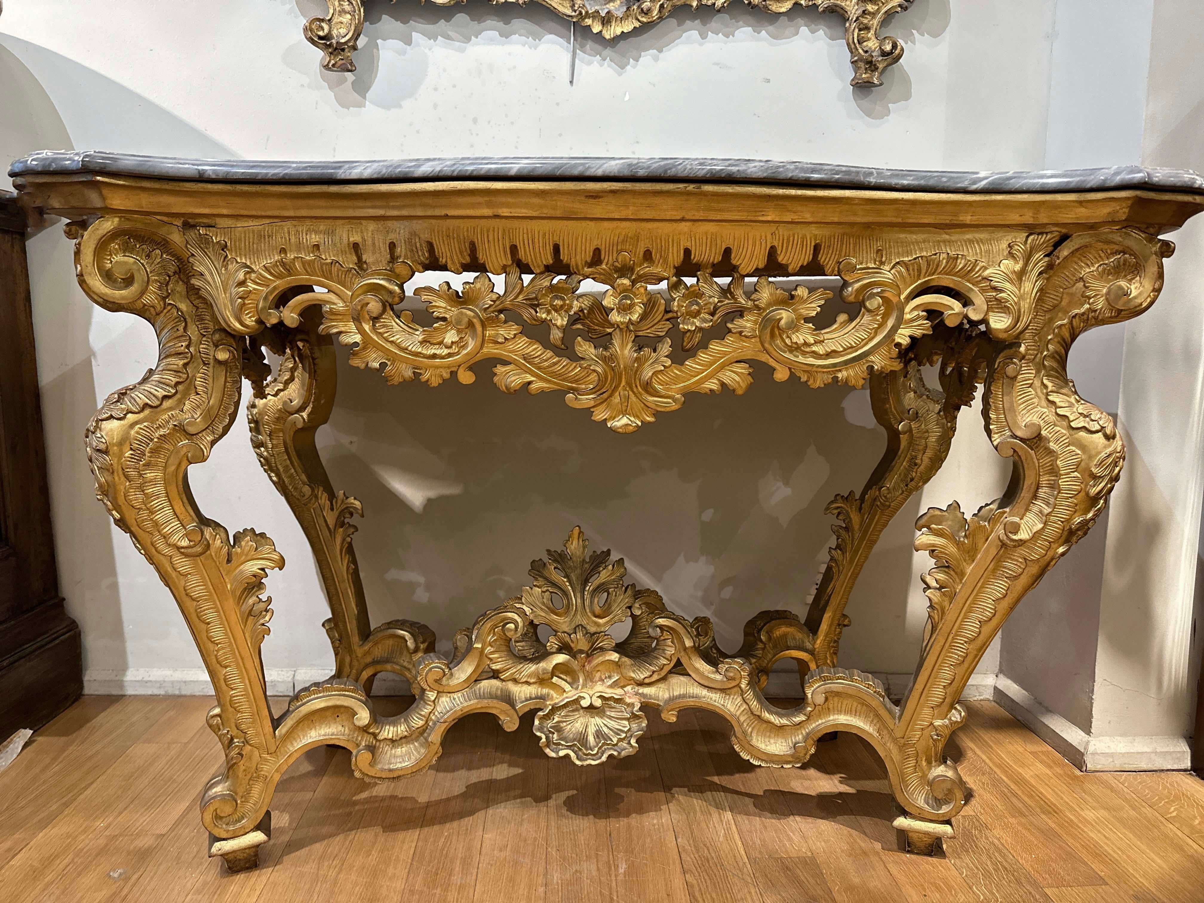This mid-18th century Tuscan console, belonging to the Louis XV period, is a piece of furniture of great elegance. Expertly crafted from fine pine wood, it was carved and gilded with extreme care, giving the piece a refined appearance. The legs of