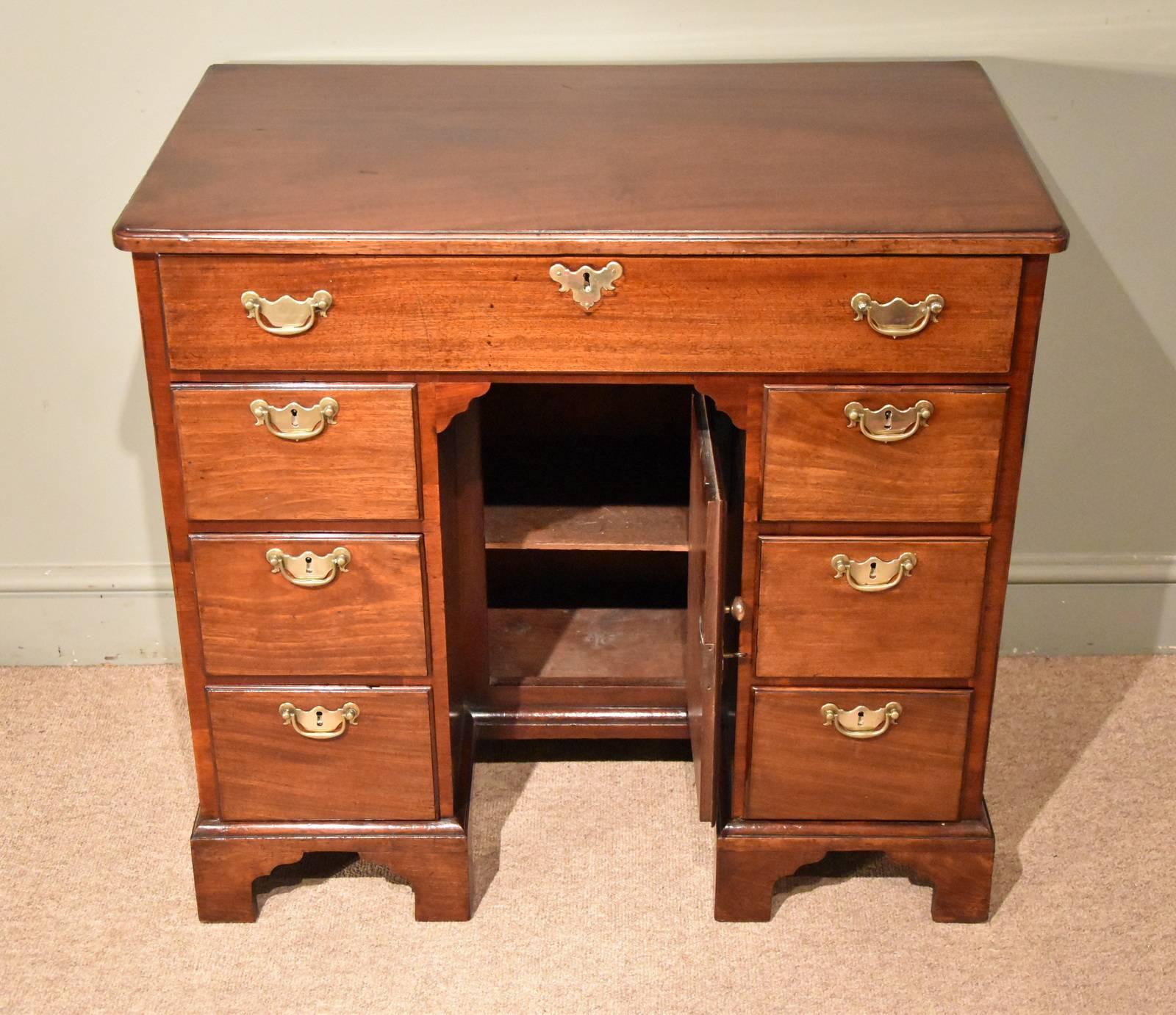 Mid-18th century mahogany kneehole desk with central cupboard. Original brasses and all on bracket feet.

Dimensions
Height 31.5