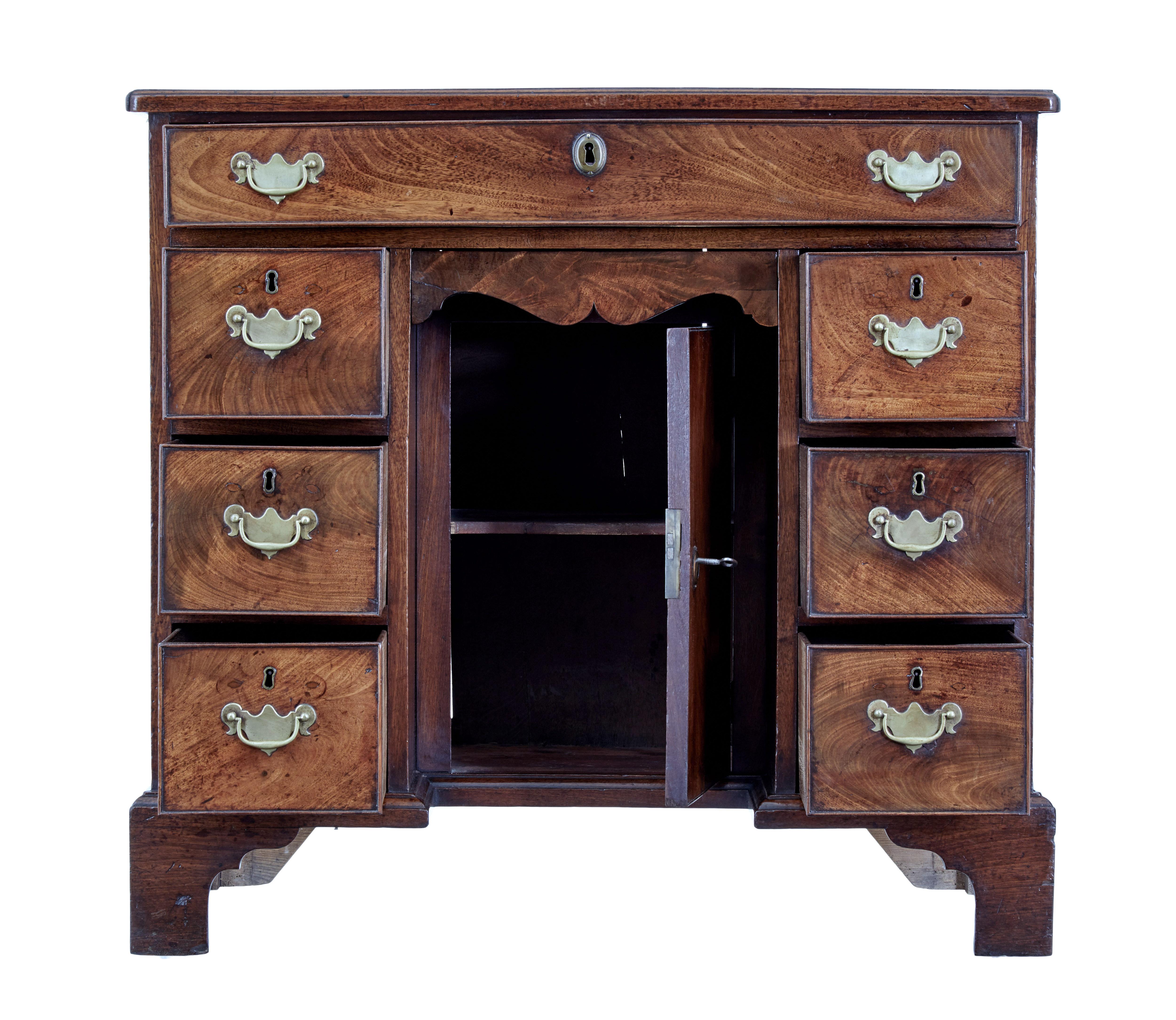 Mid 18th century mahogany kneehole desk circa 1750.

Georgian mahogany kneehole desk or writing table with 1 piece writing surface.   Central kneehole with cupboard and a shaped drawer above the knee is flanked either side by a bank of 3 drawers,