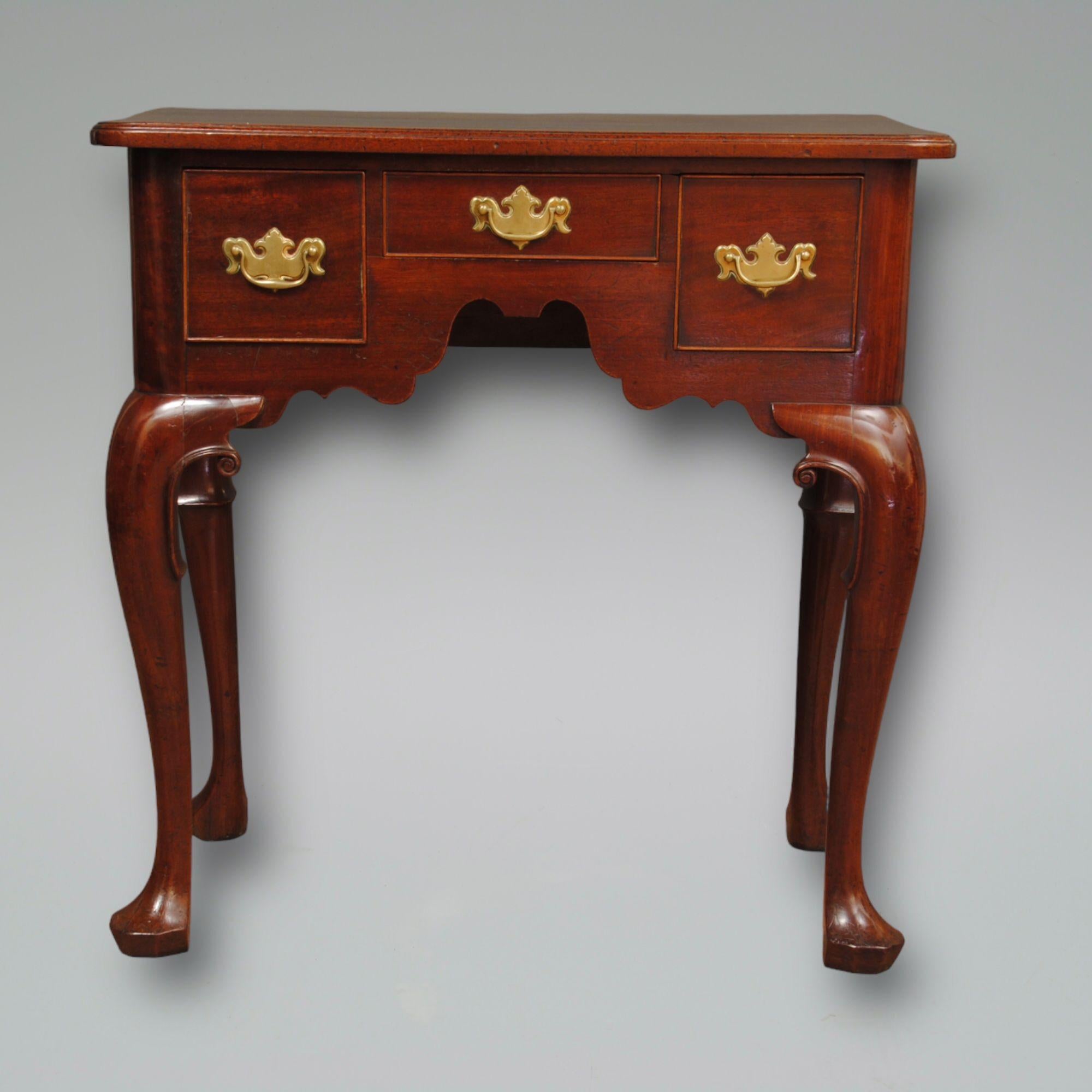 A lovely example of a Georgian mahogany lowboy with cabriole legs and carved scolls, original handles and great colour and patination.
       