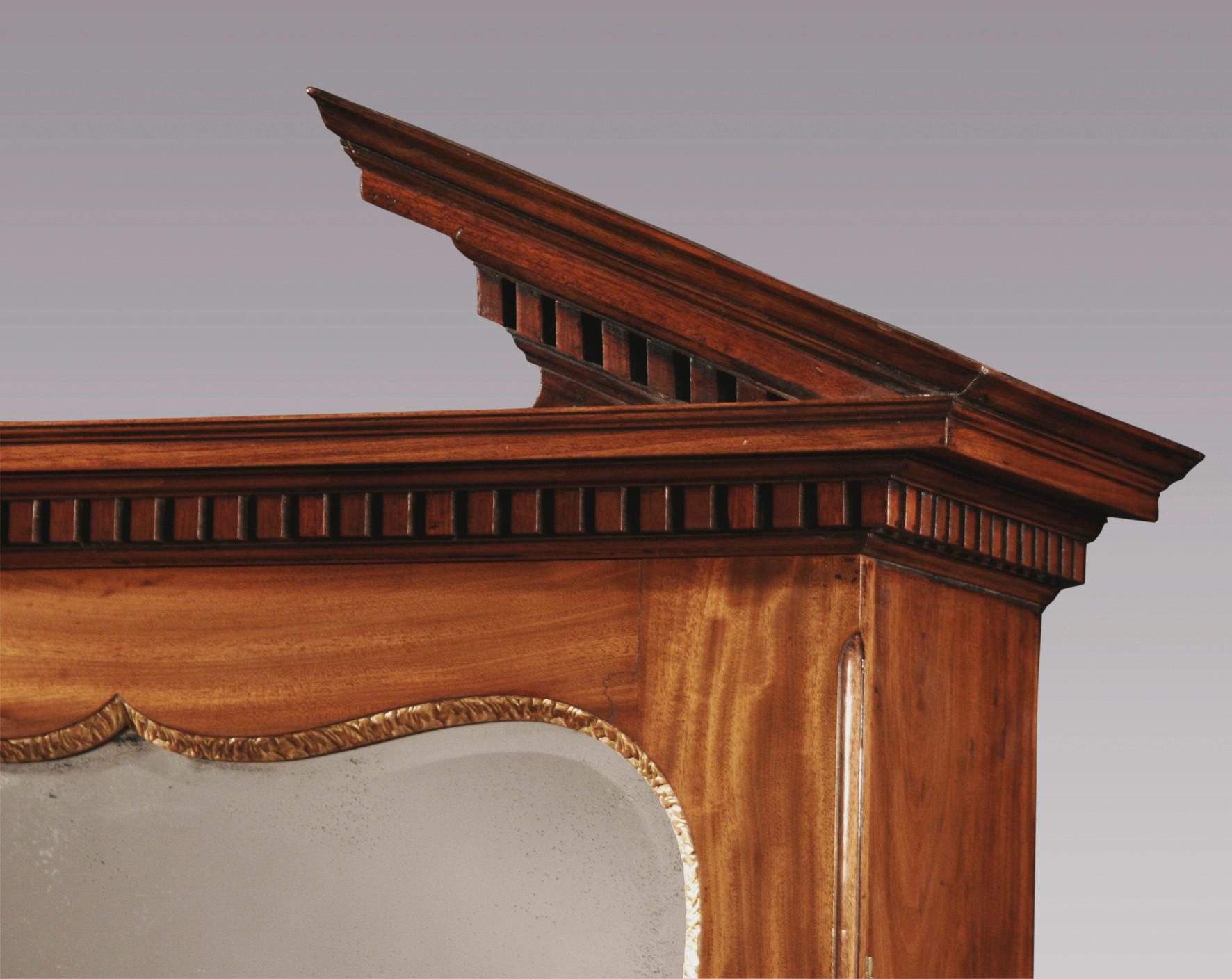 Libreria Bureau in mogano della metà del XVIII secolo, di piccole proporzioni, con cornice architettonica a dentelli e porta a specchio sagomata con cornice originale dorata. La libreria ha un interno ben arredato con quattro cassetti graduati
