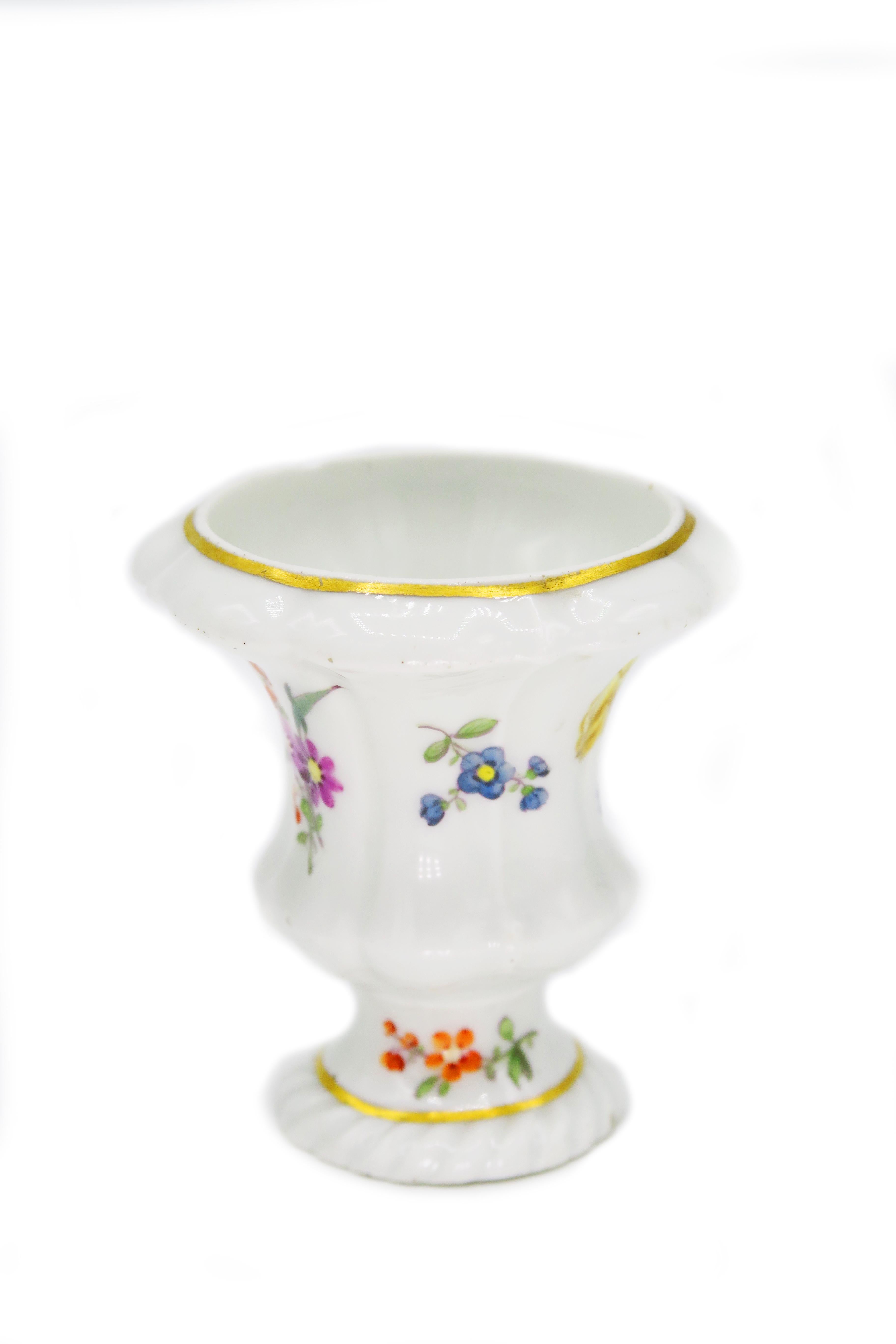 Mid-18th century Meissen model miniature vase.

Round, flared Stand, short shaft, urn-shaped body, slightly flared lip edge.
The vase depicts a natural bouquet. Gold tufted edges. Model: J. J. Kaendler

Meissen Modell Miniatur-Vase
Runder,