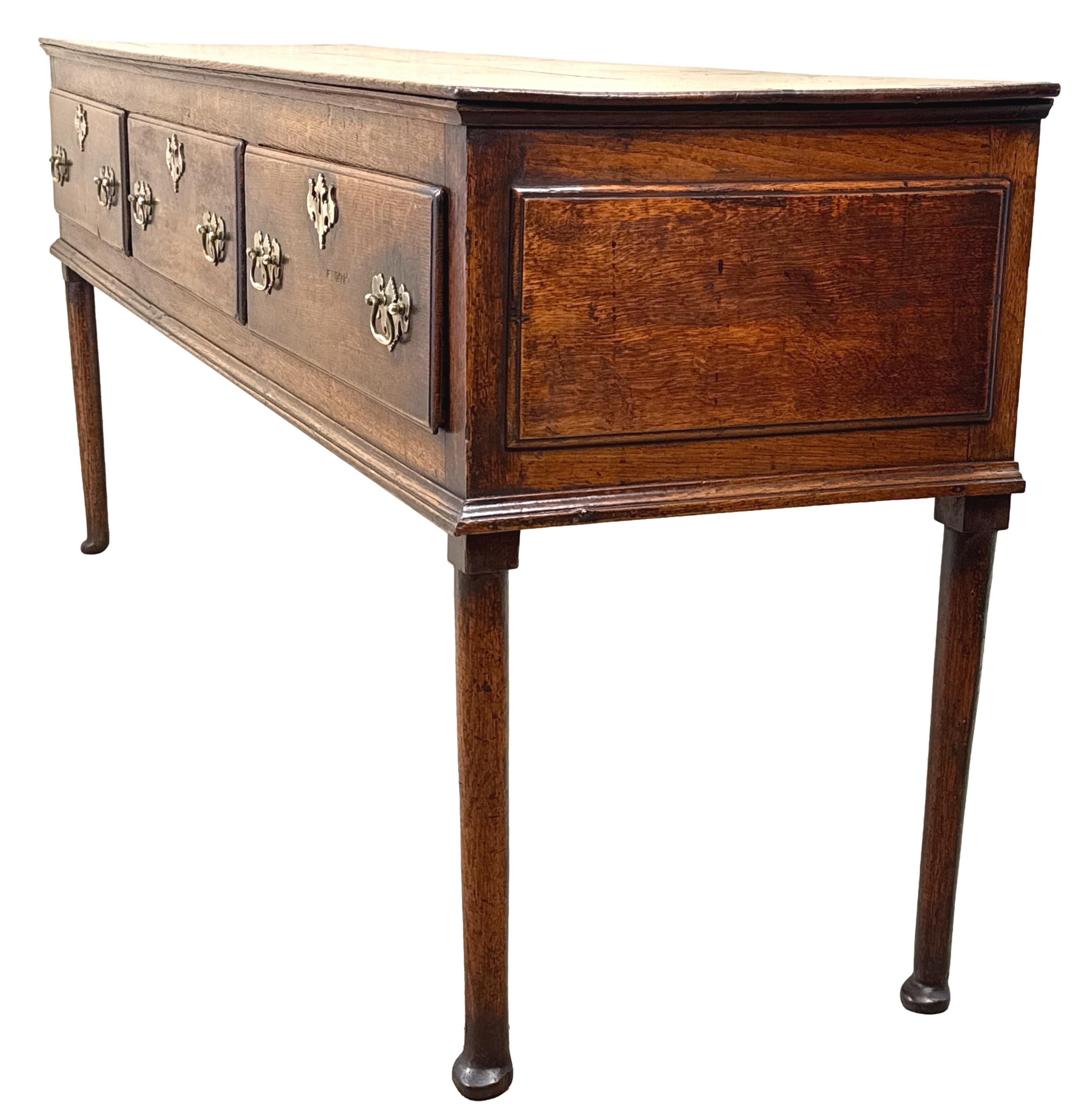 Charmante et extrêmement attrayante commode ou buffet en chêne d'époque George II, milieu du XVIIIe siècle, conservant une superbe couleur et une surface intactes, avec un plateau rectangulaire surmontant trois tiroirs en frise dotés de poignées et