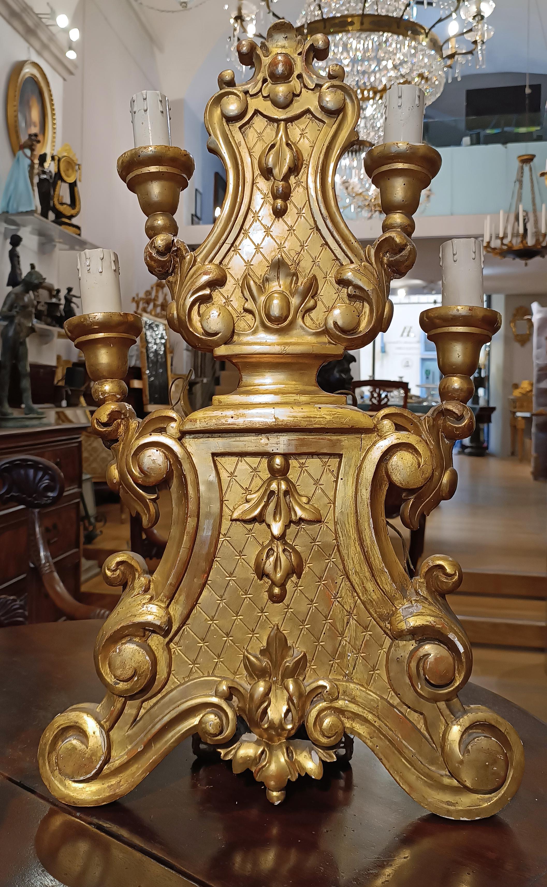 This pair of table candlesticks is a fine example of Tuscan manufacturing from the mid-18th century. Made of carved wood and finely gilded in pure gold, these candlesticks exhibit high craftsmanship and refined aesthetic taste. Their 