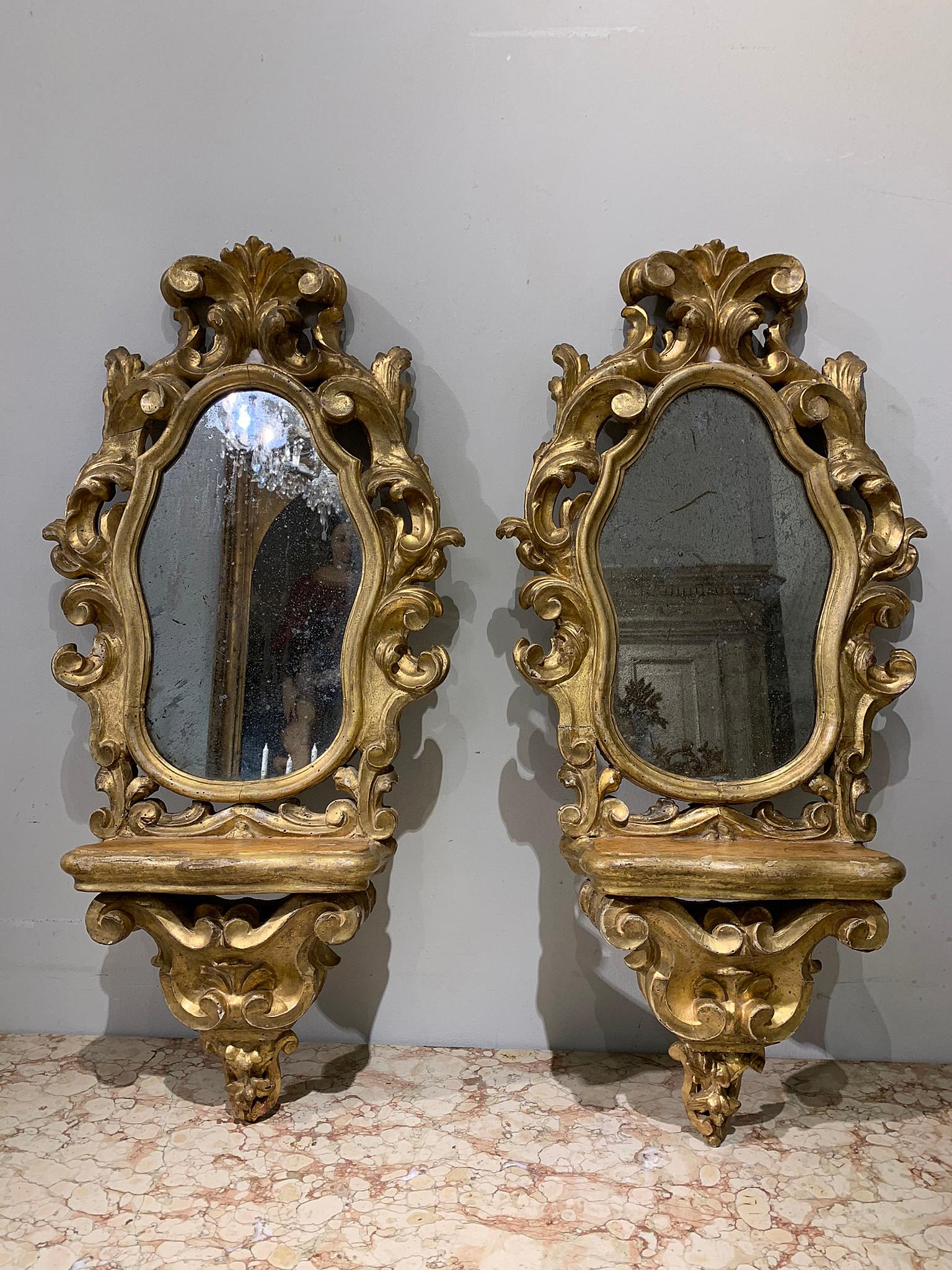 Elegant pair of mirrors in carved and gilded wood with the 
