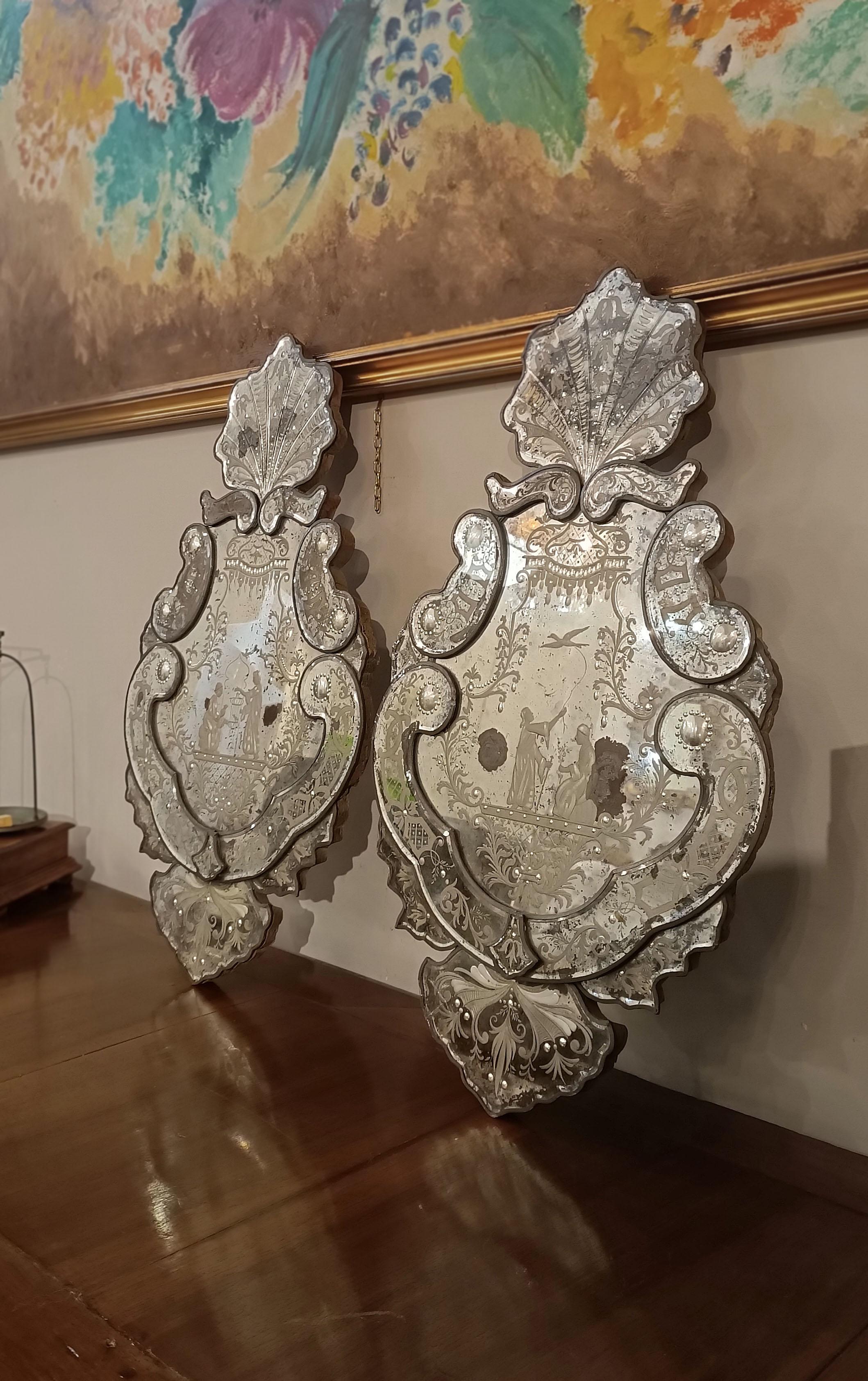 Prächtige kleine gebogene und gewellte Spiegel aus versilbertem Quecksilberglas. Diese Spiegel, die sich durch eine gewellte Form und verschlungene Ornamente auszeichnen, haben eine Muschel auf der Oberseite und sind mit raffinierten Gravuren