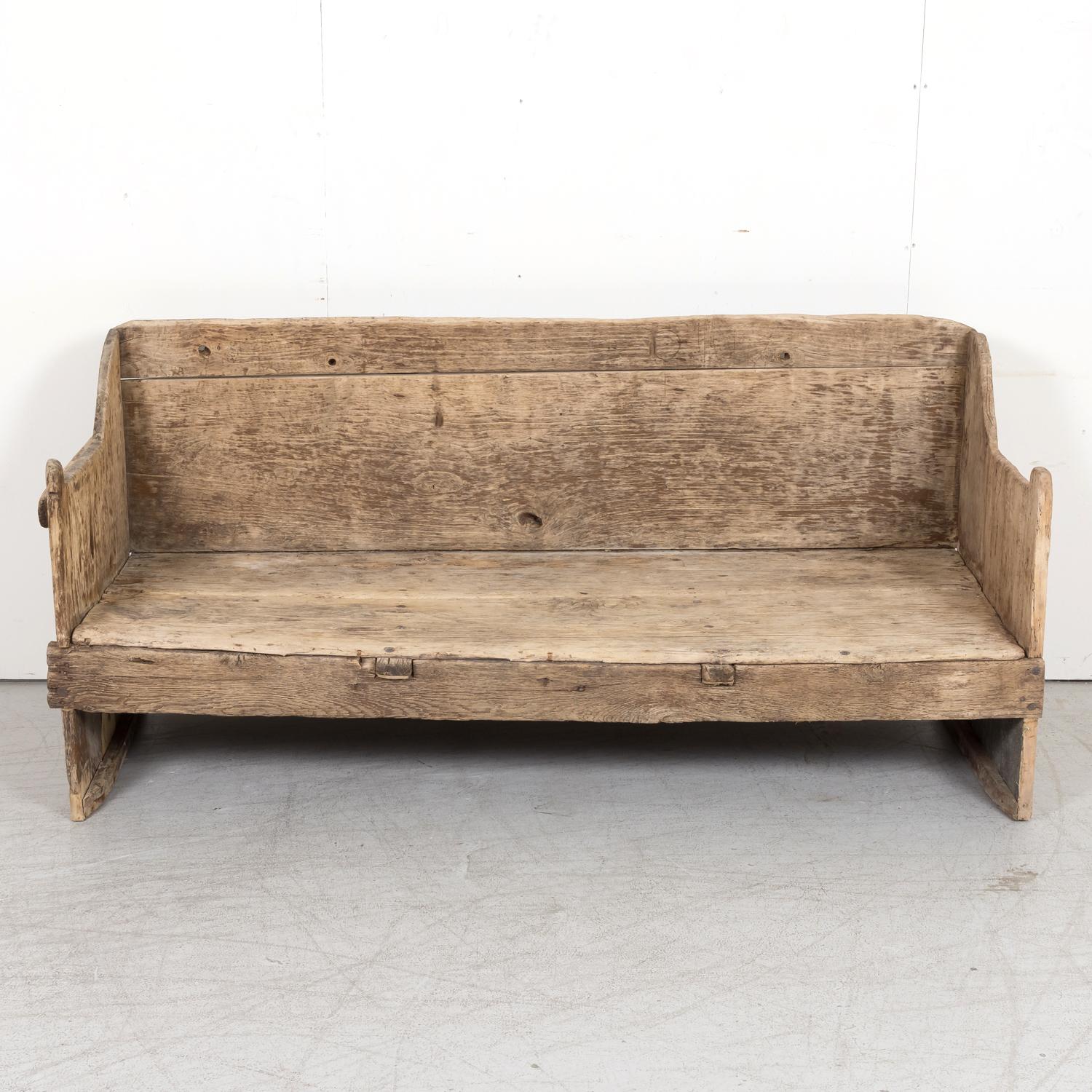 A very handsome late 17th century primitive bench from the Catalan region of Spain, circa 1680s. Handcrafted of pine, this Spanish bench features plank construction and an amazing sun washed patina that has weathered beautifully over the last two