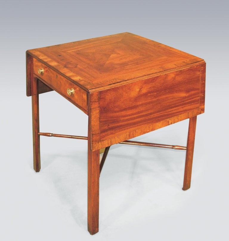 A mid-18th century mahogany Pembroke table having boxwood and ebony inlaid, padouk wood crossbanded and mitred top, above satinwood frieze drawer supported on chamfered legs with turned cross-frame stretcher ending on leather castors. Flaps down: