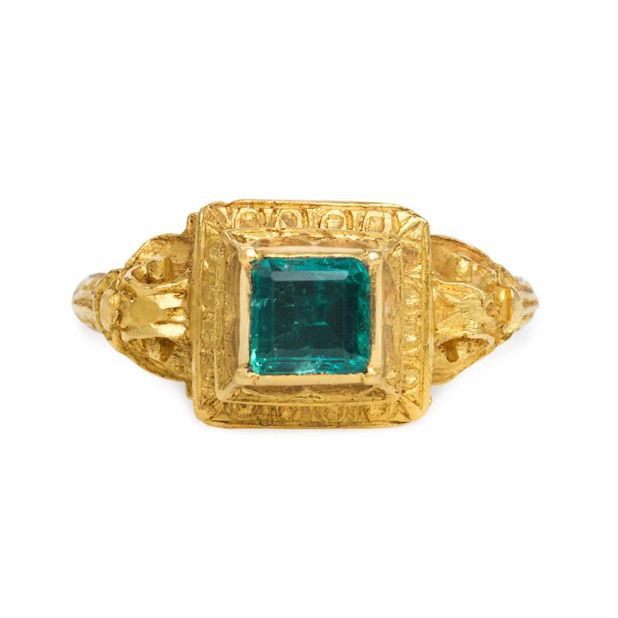 An antique carved gold and emerald ring in the Renaissance style with foliate scrolled shoulders and engraved detail on underside, in 18k.  French import.  (Antique box included but not original to the ring)

Dimensions of square top: 5/16