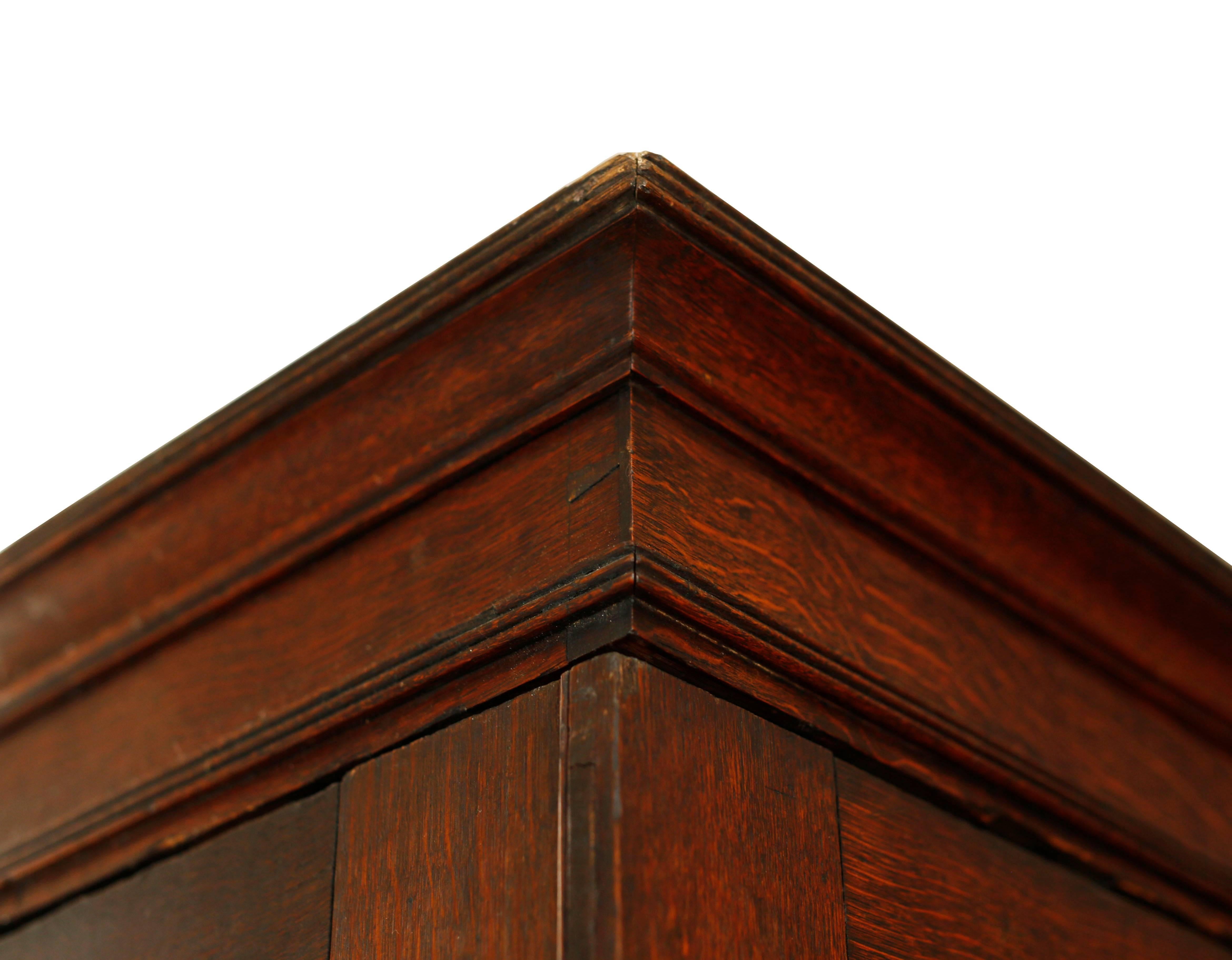A stunning armoire with clean simple lines and masculine, handsome proportions. The coloring is particularly fine with a deep amber hue. The case sits on bun feet with concealed castors. A simple Covetto cornice crowns the top with fine incised