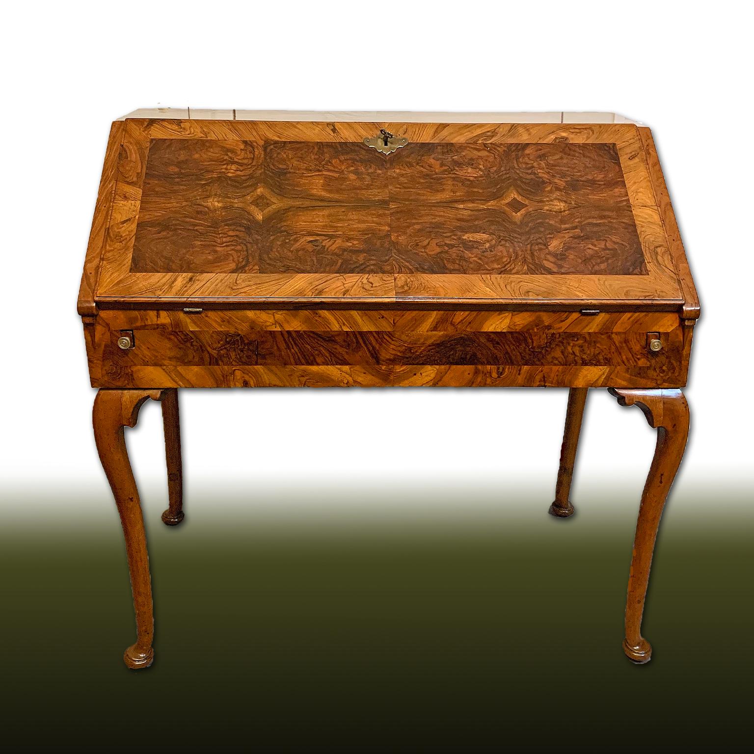 Elegant writing desk with walnut veneered drop-leaf top with solid wood parts. Particular for the contained dimensions and the wavy legs on a linear upper body. The possibility of using it as a foot desk is pleasant thanks to a small frame to