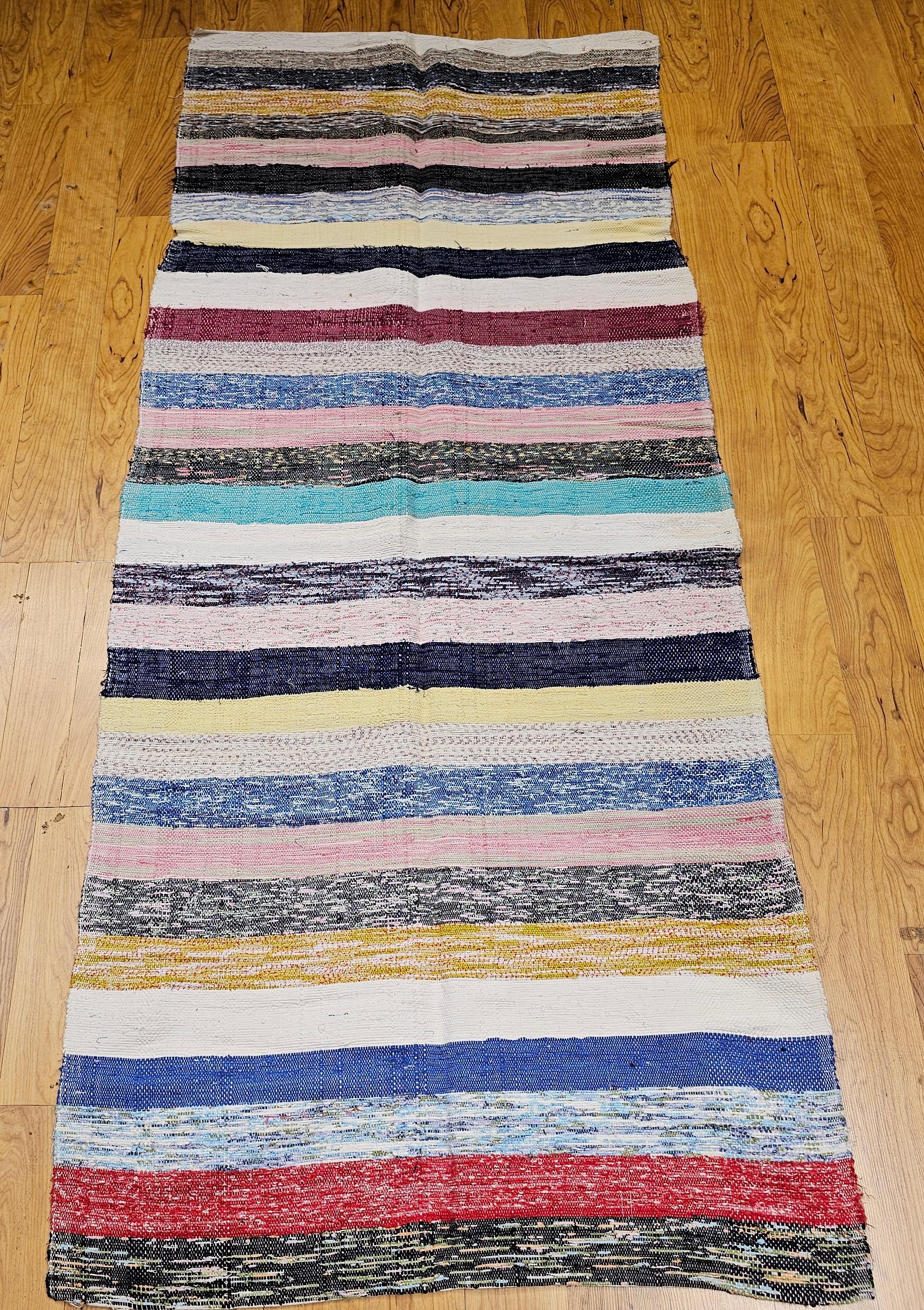 This striking American rag rug from the mid 1900s features a beautifully modern aesthetic, blending timeless craftsmanship with a distinctly contemporary feel. Woven in a series of horizontal bands in warm, natural earth tones, the rug’s design