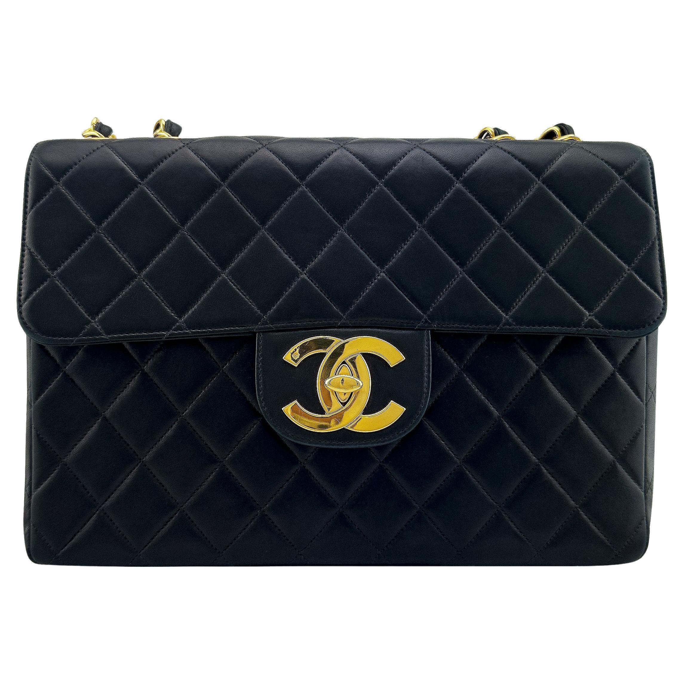 Timeless and highly collectable Chanel jumbo flap bag by Karl Lagerfeld dating from 1996/1997. Crafted from Chanel's iconic supple black quilted lambskin leather with very substantial 24 karat gold chain and large interlocking CC logo at front. 24