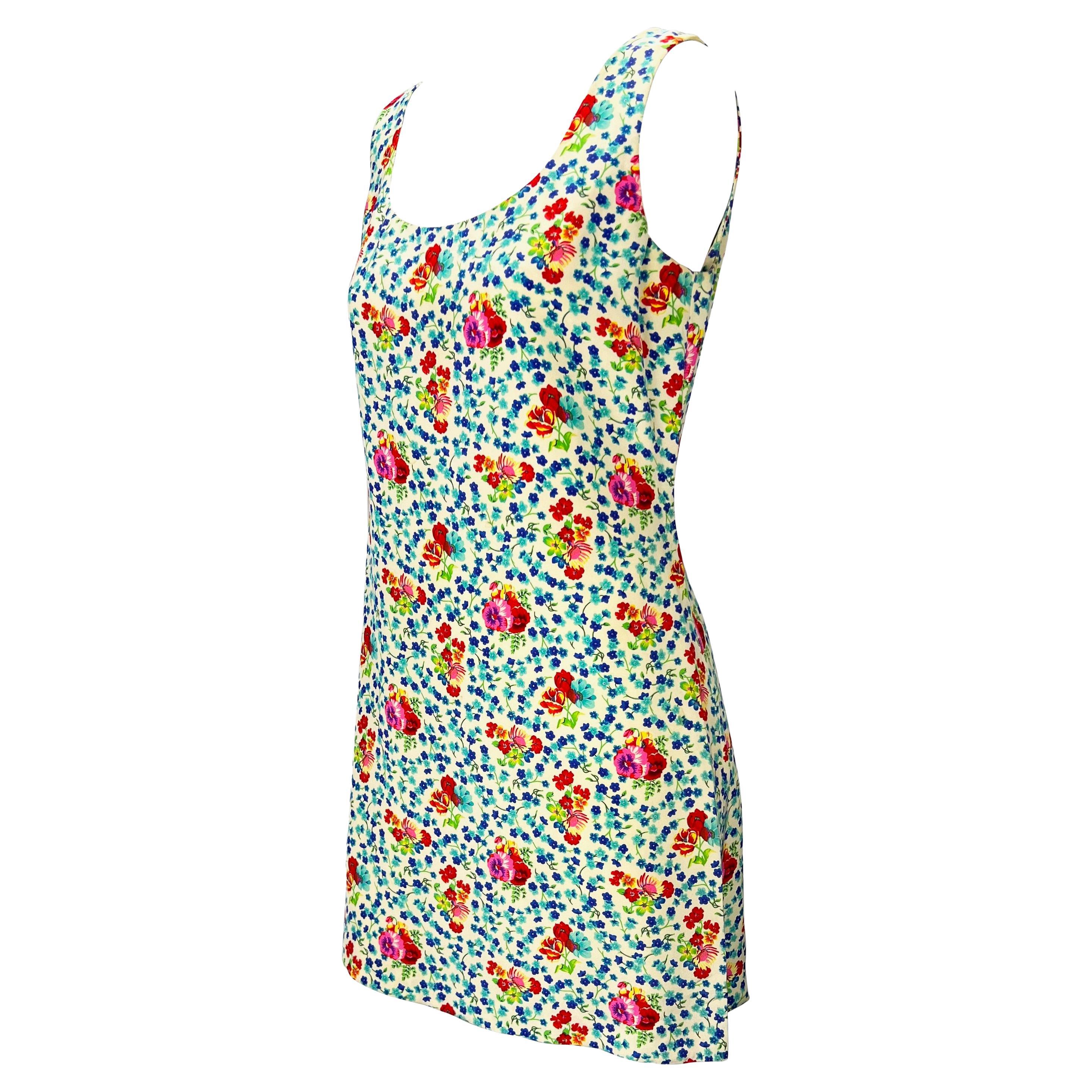 Presenting a classic floral dress, designed by Gianni Versace. From the mid-1990s this vibrant off-white sleeveless dress is covered in a bright floral print. The dress features a scoop neckline and a midi cut. 

Approximate measurements:
Size -