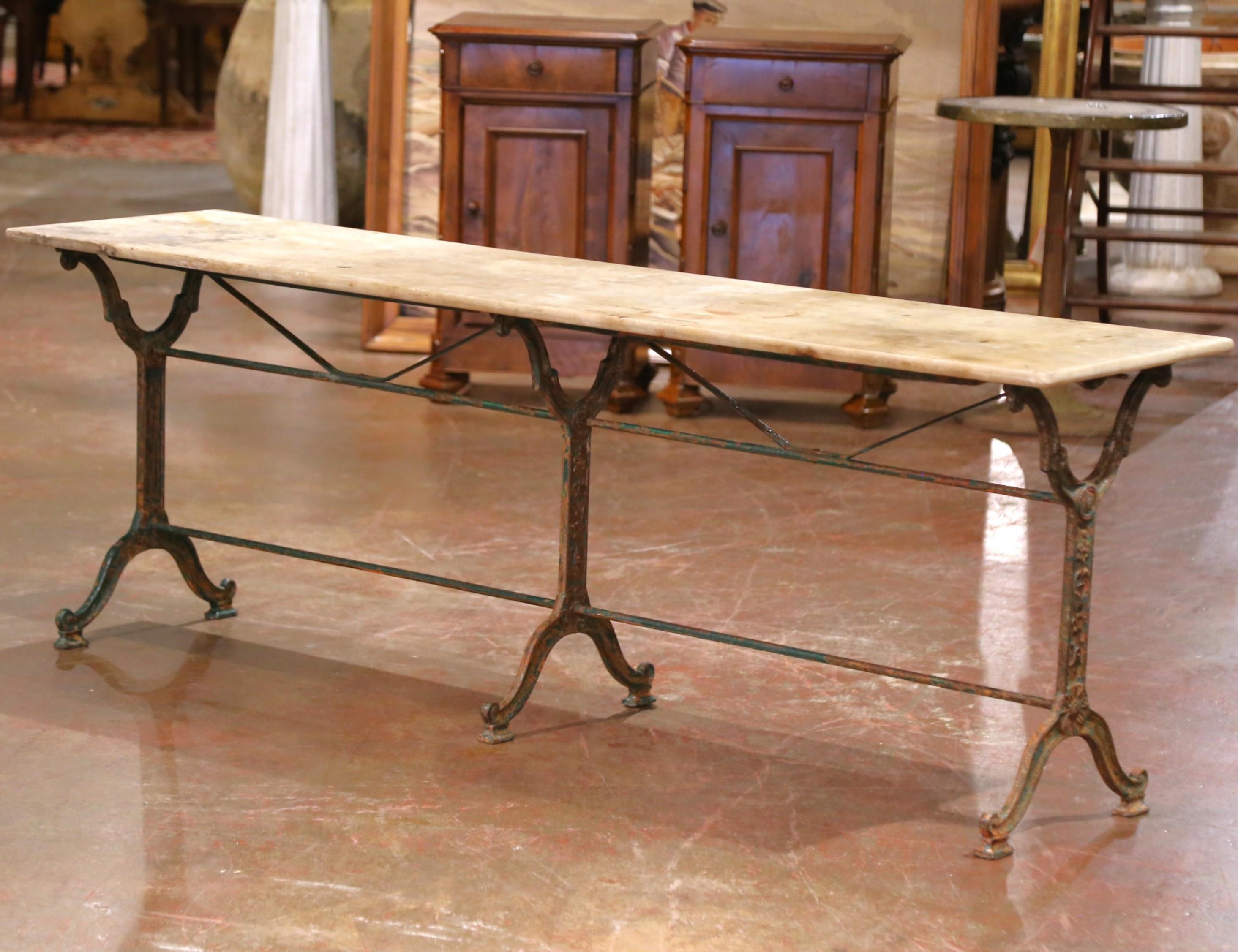 Decorate an outdoor patio or porch with this rare and unusually long antique bistrot table. Crafted in France circa 1860, this elegant pastry table features its original marble top, beautifully aged with soft discoloration, light veining, and