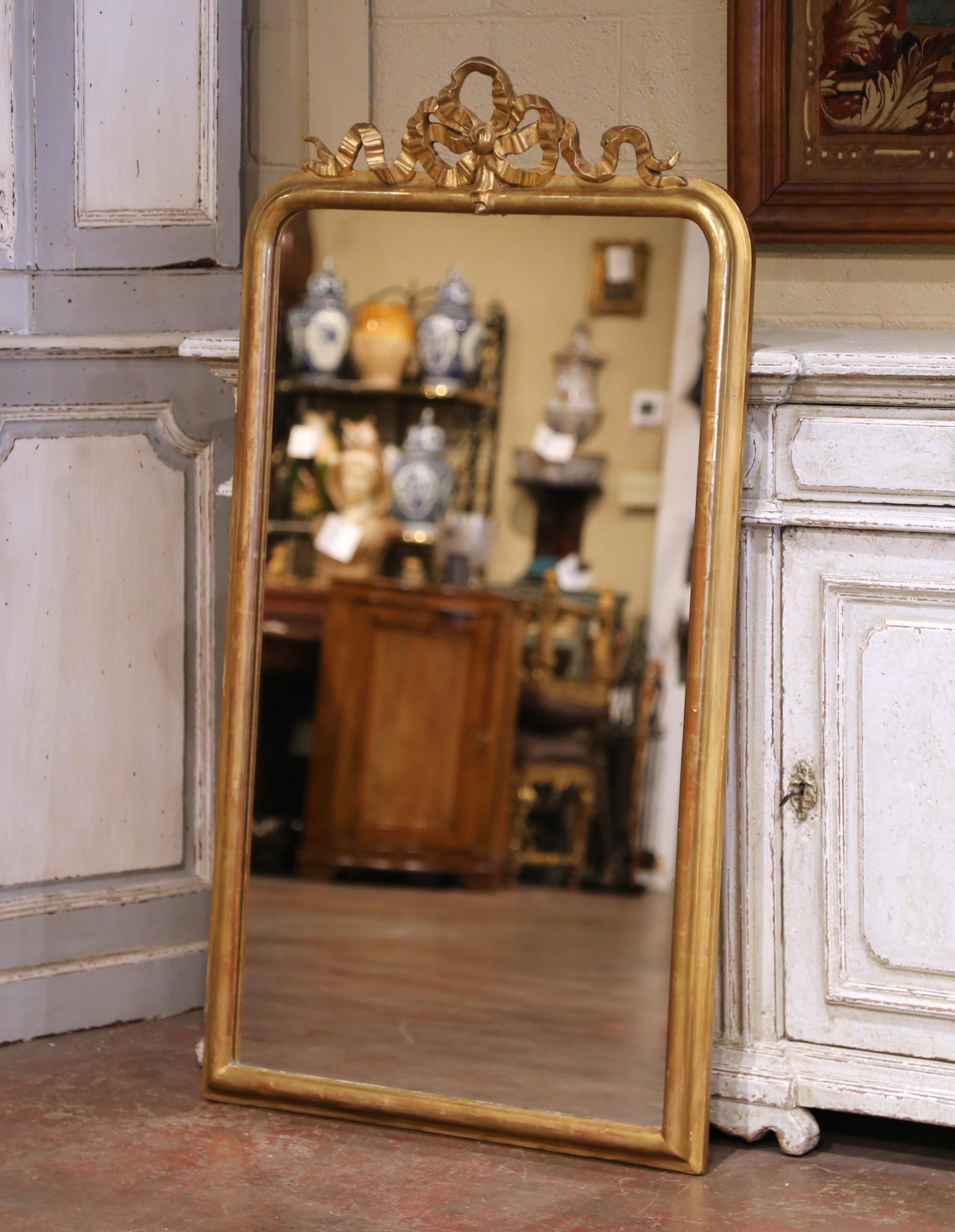 Apporta un raffinato fascino neoclassico ai tuoi interni con questo elegante specchio antico francese, realizzato nel 1870 circa in stile Luigi XVI. La cornice in legno intagliato a mano è coronata dal motivo decorativo caratteristico di questo