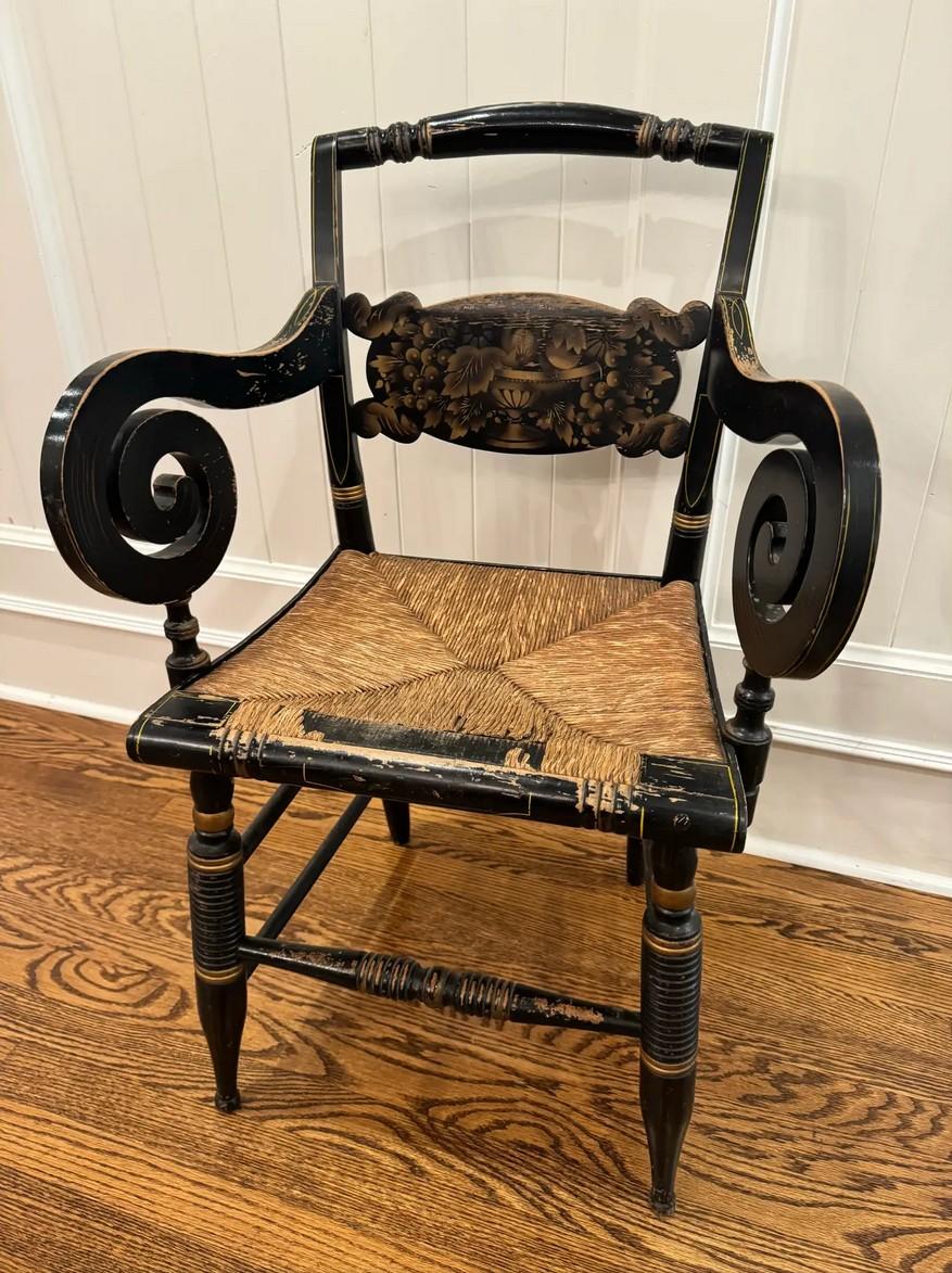 Un magnifique fauteuil signé Hitchcock datant du milieu du XIXe siècle, mettant en valeur le savoir-faire intemporel des premiers meubles américains. Le cadre en bois massif présente la finition peinte noire classique de la marque, accentuée par un