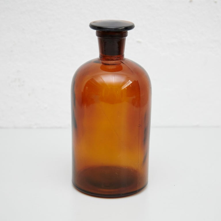 Mid-19th century amber apothecary glass bottle with lid.
By unknown manufacturer from France.

In original condition, with minor wear consistent with age and use, preserving a beautiful patina.

Materials:
Amber glass

Dimensions:
ø 9.5 cm