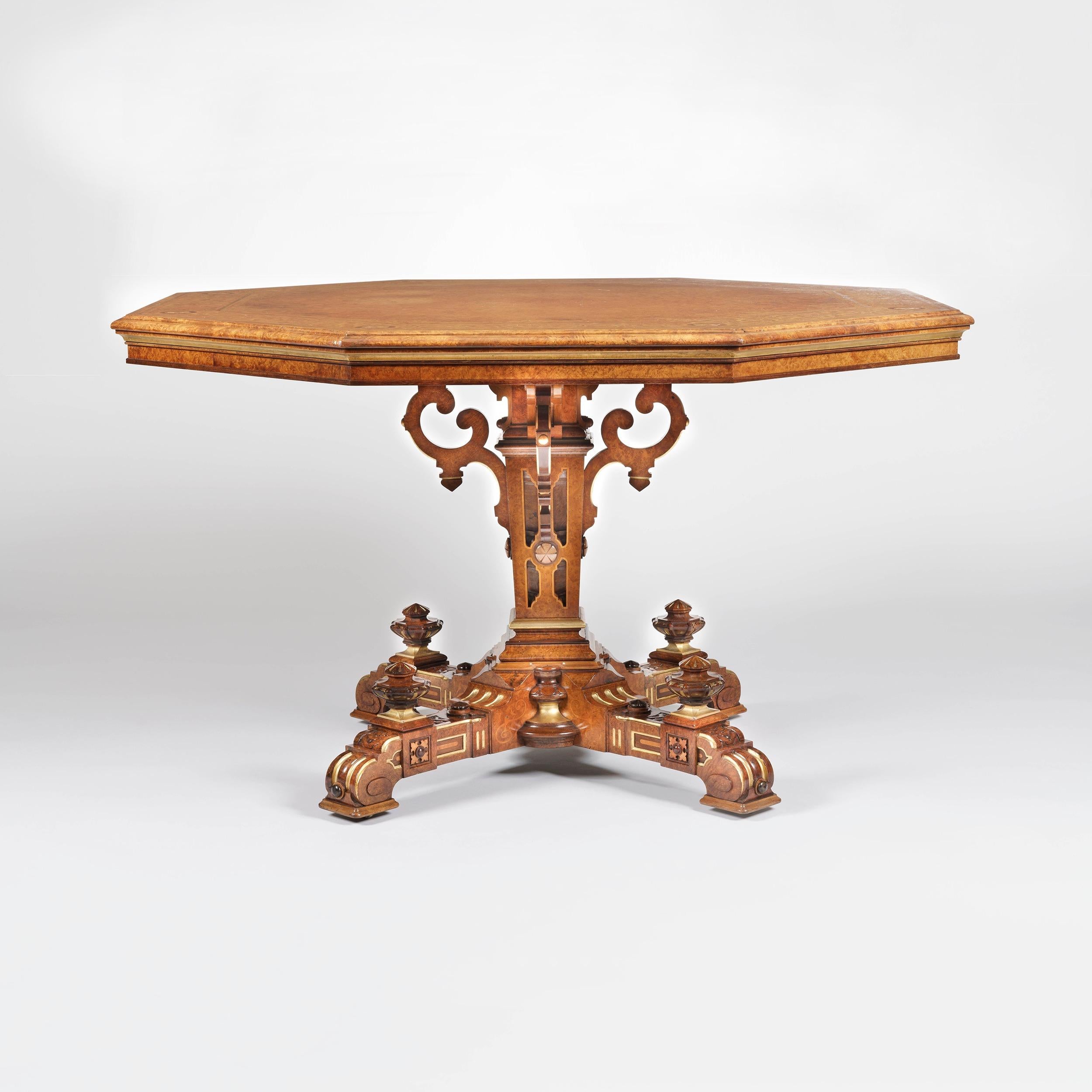 A good centre table
 by Johnstone & Jeanes of London
 
Constructed in amboyna, with extensive marquetry inlays in specimen woods, and enhanced with parcel-gilt highlights. Rising from a cruciform platform base adorned with knops and having concealed
