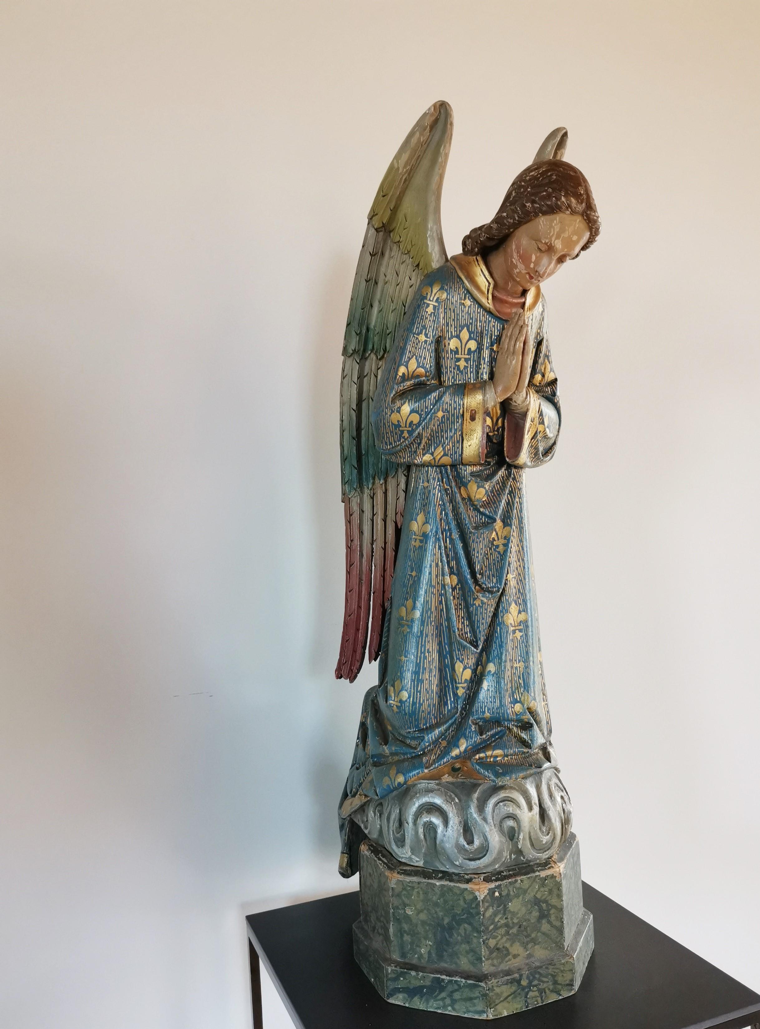 Mid 19th century French, parcel gilt and polychrome wood carved angel, coming from a convent near Ghent (Lede). Winged Gabriel kneeling on it's faux marble painted base, still in good condition with minor losses on the gilding and polychrome. The