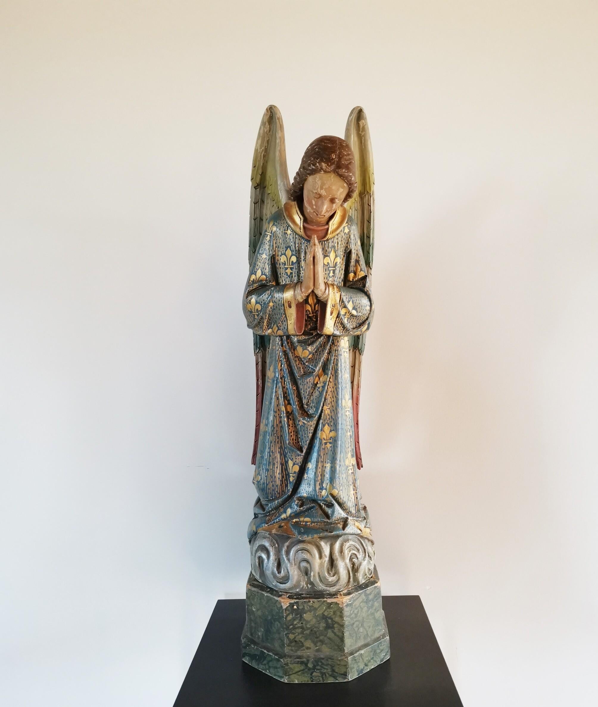 Mitte des 19. Jahrhunderts französischer, paketvergoldeter und mehrfarbig geschnitzter Engel, der aus einem Kloster in der Nähe von Gent (Lede) stammt. Geflügelter, kniender Gabriel auf einem Sockel aus Kunstmarmor, noch in gutem Zustand mit kleinen