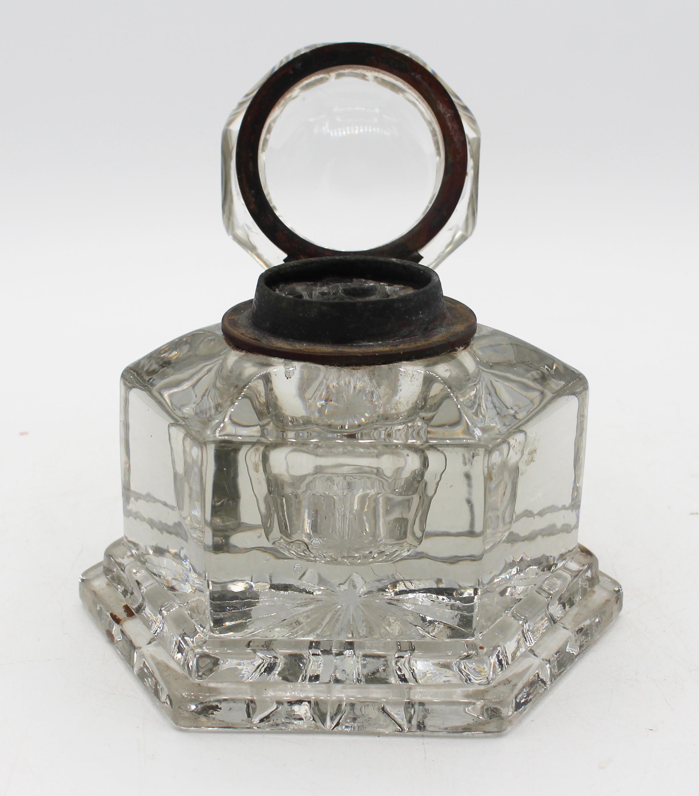 Mid-19th century Anglo-French mold & cut glass inkwell. Brass collar. Fine condition with a few tiny nicks on bottom. Hexagonal body over conforming, stepped base; molded, octagonal lid; cut star base underside adds visual interest.
5 1/8