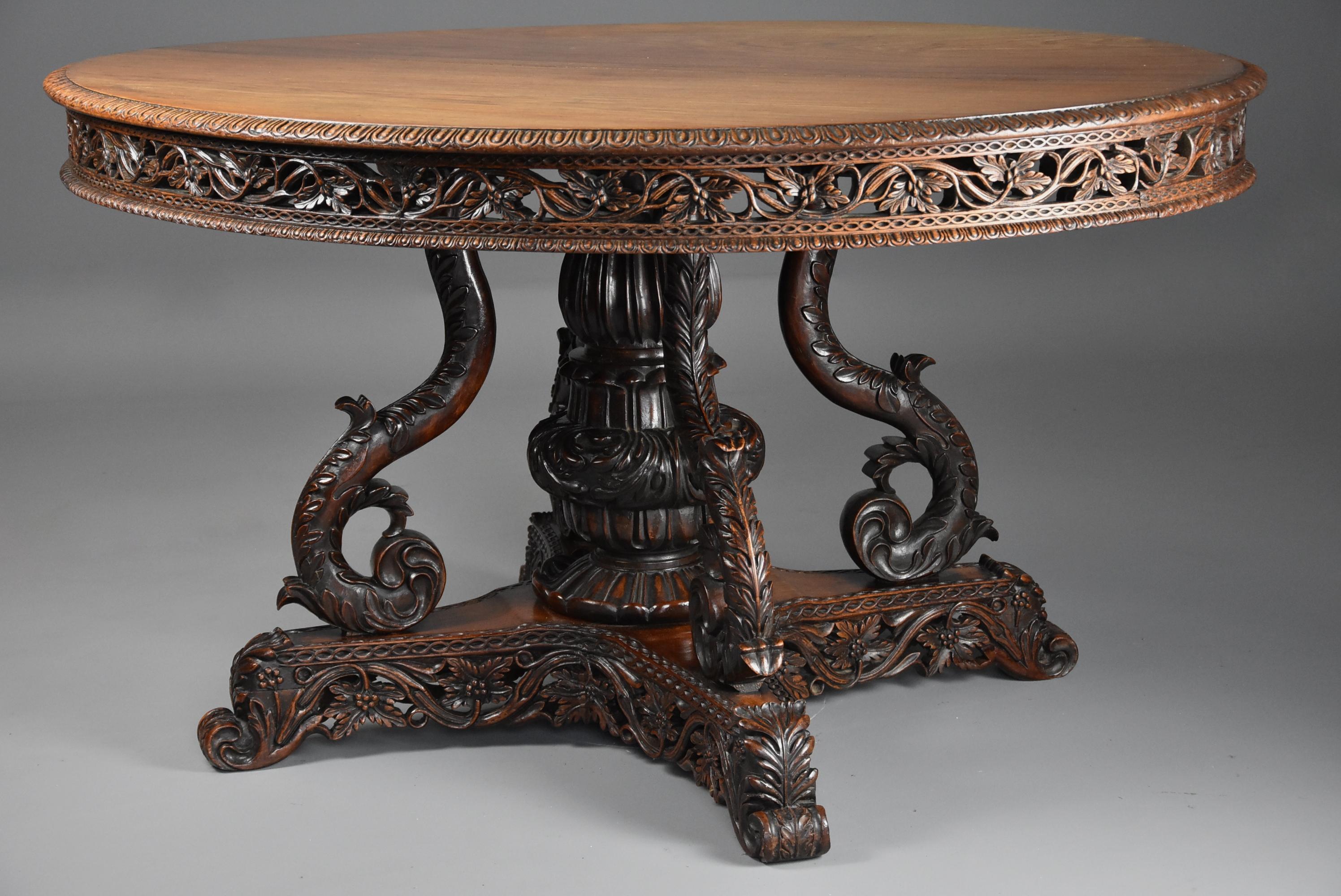 A mid-19th century Anglo Indian padouk centre table of oval form with superb faded patina (color) probably from the Bombay region of India.

This table consists of a superbly faded solid padouk oval top with carved moulded edge leading down to a