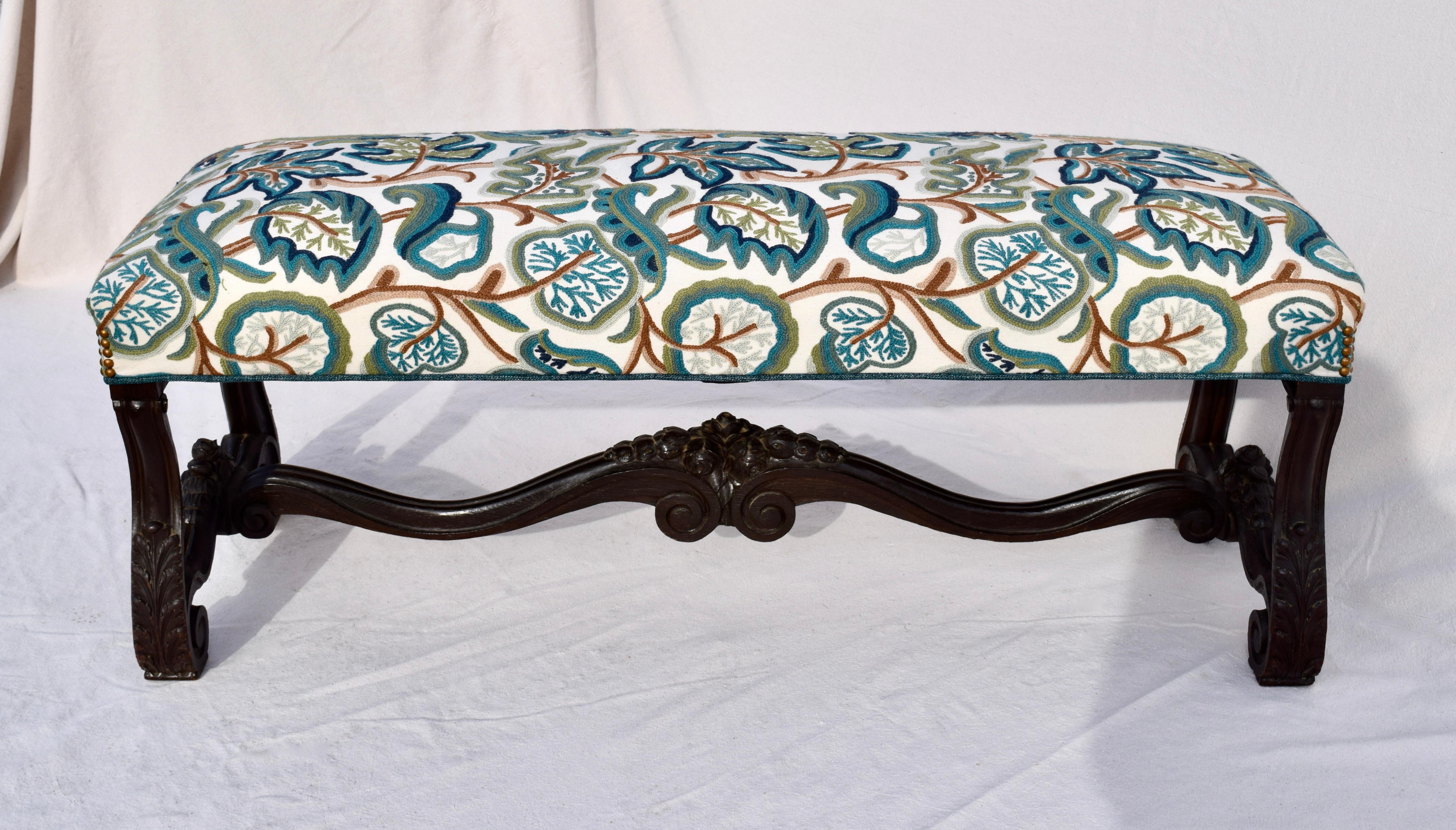 A mid-19th century Empire bench fully restored and upholstered in English embroidered & imported crewel fabric. Intricate  hand carved & scroll form base with substantial stretcher. The original spring interior has been re-strung and tied.  An