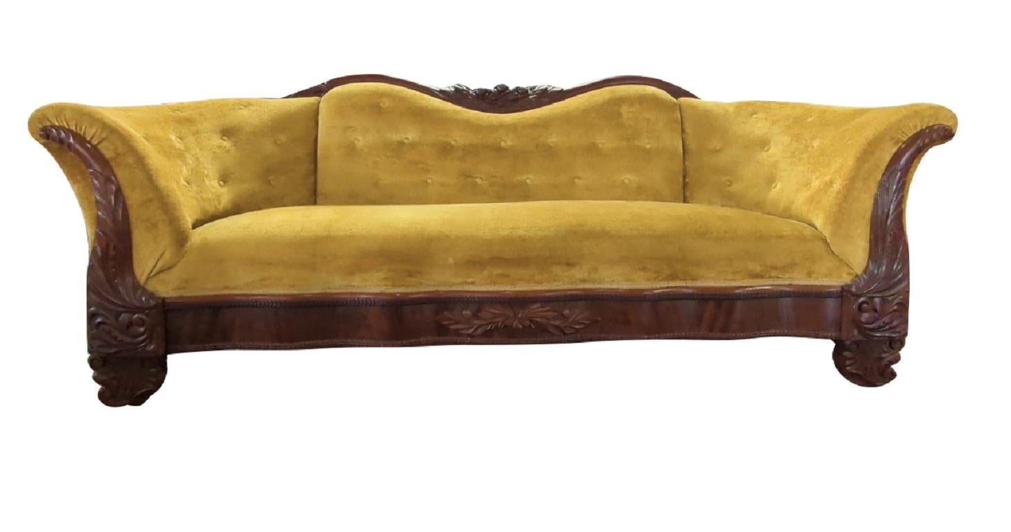 Gorgeous antique sofa, American Empire, Victorian, Flaming Mahogany frame, Ornate carvings on top, Upholstered front, seat and back, Golden yellow color velveteen upholstery, Button tufting, Cushion is firm but comfortable, Overall very sturdy,