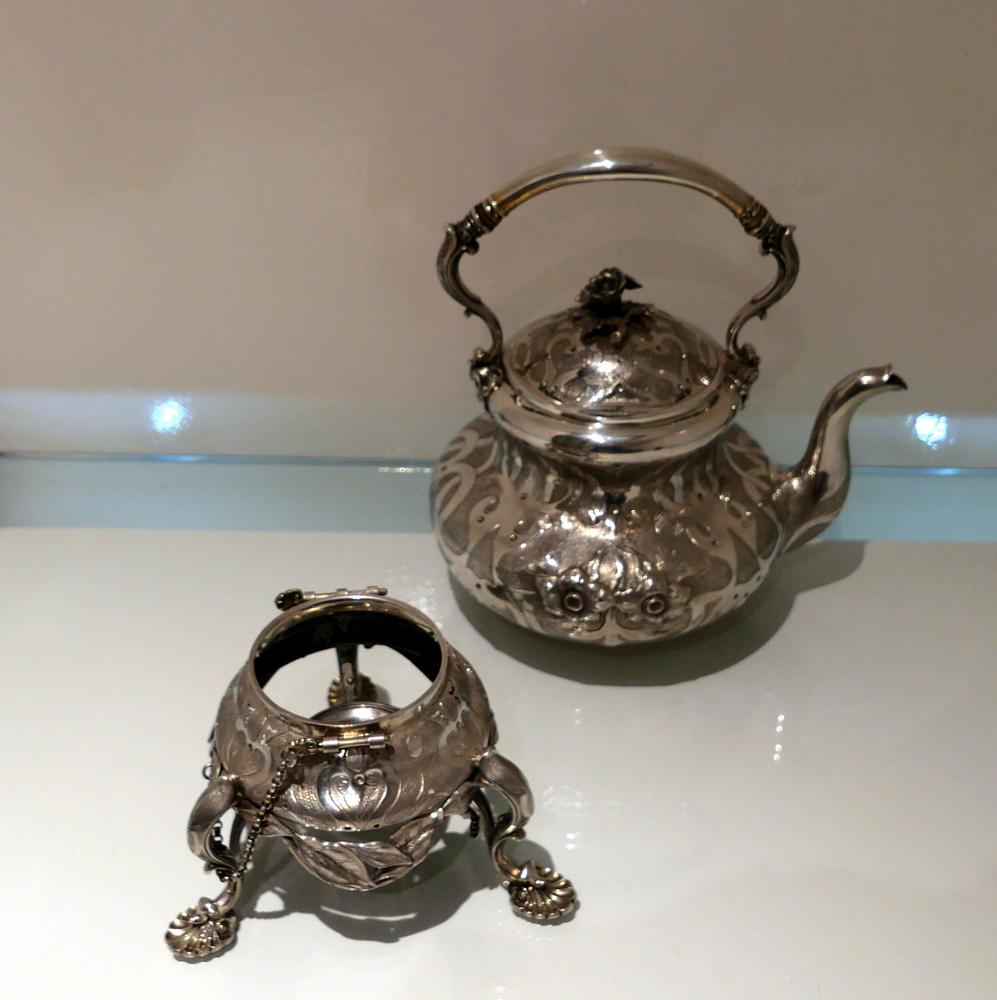 A rare silver Victorian tea kettle on stand made for the Russian market. The body has ornate floral designs which is set on a matt background with plain formed ‘streams’ entwining the decoration. The lid is hinged and the handle is fixed. The