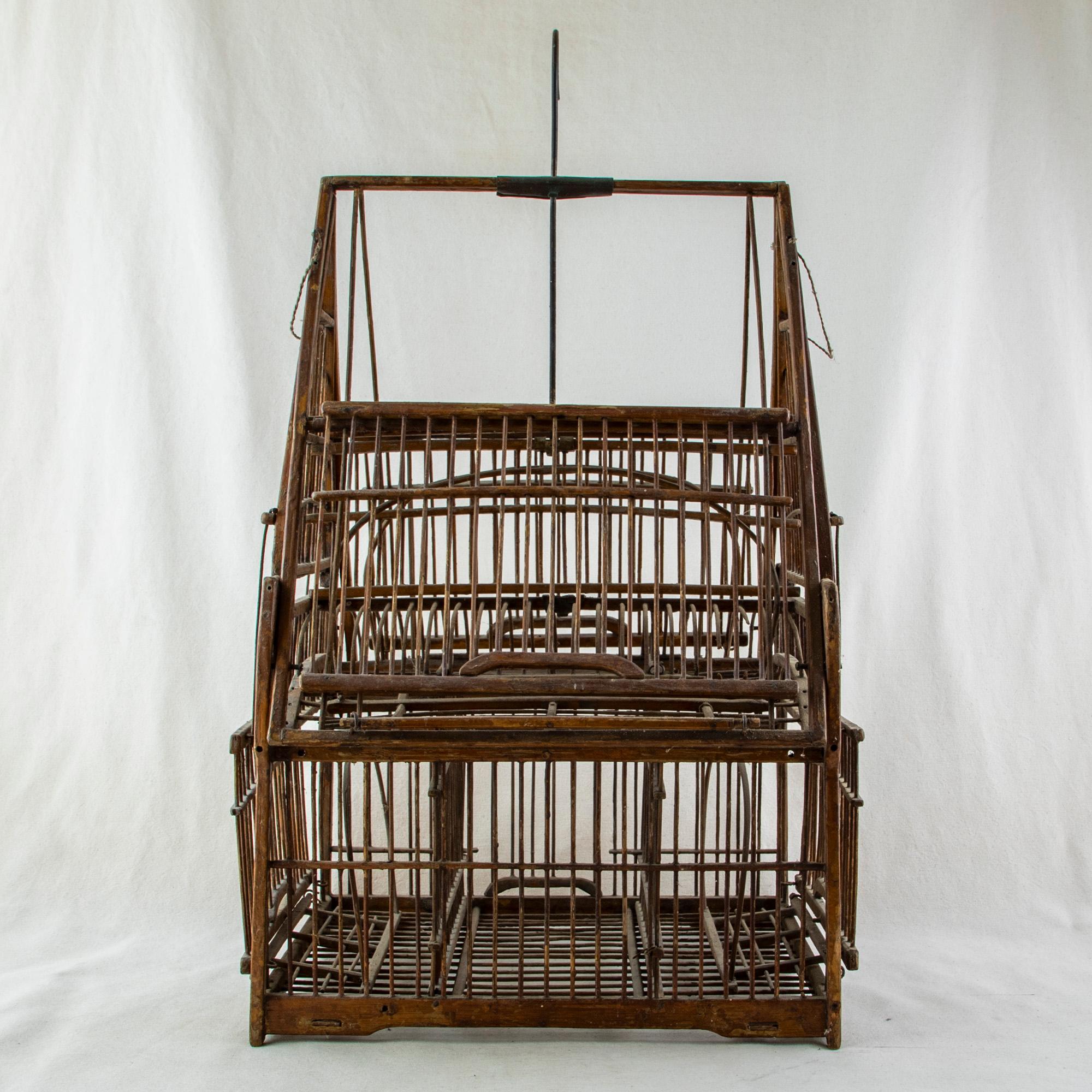This mid-nineteenth century artisan-made Chinese birdcage is constructed of wood and wire and features several compartments accessed by sliding doors. The cage has a central hook at the top allowing it to be hung from the ceiling. c. 1860.